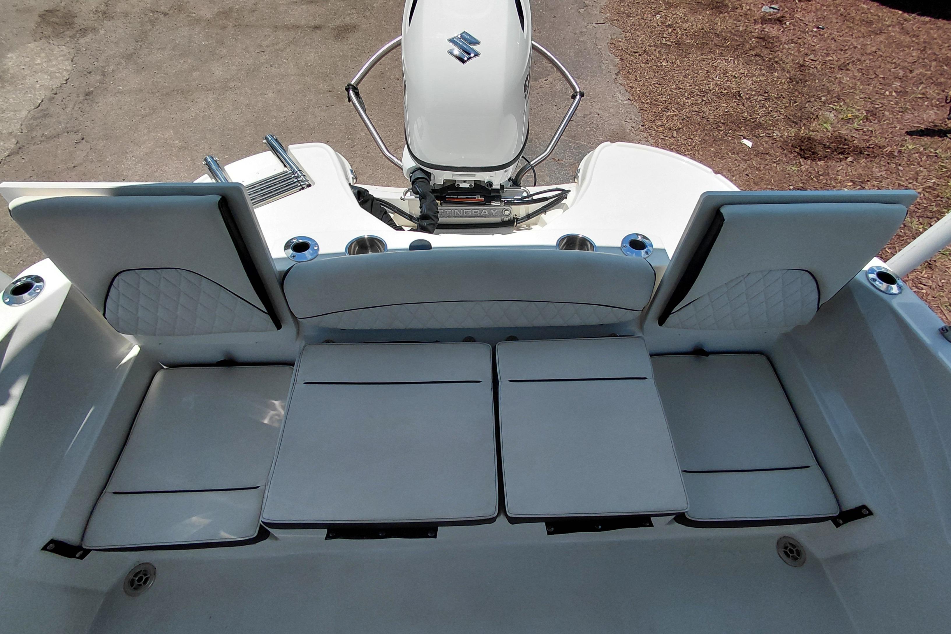 2023 Stingray 206 CC boat interior with cushioned seating and Suzuki outboard motor.