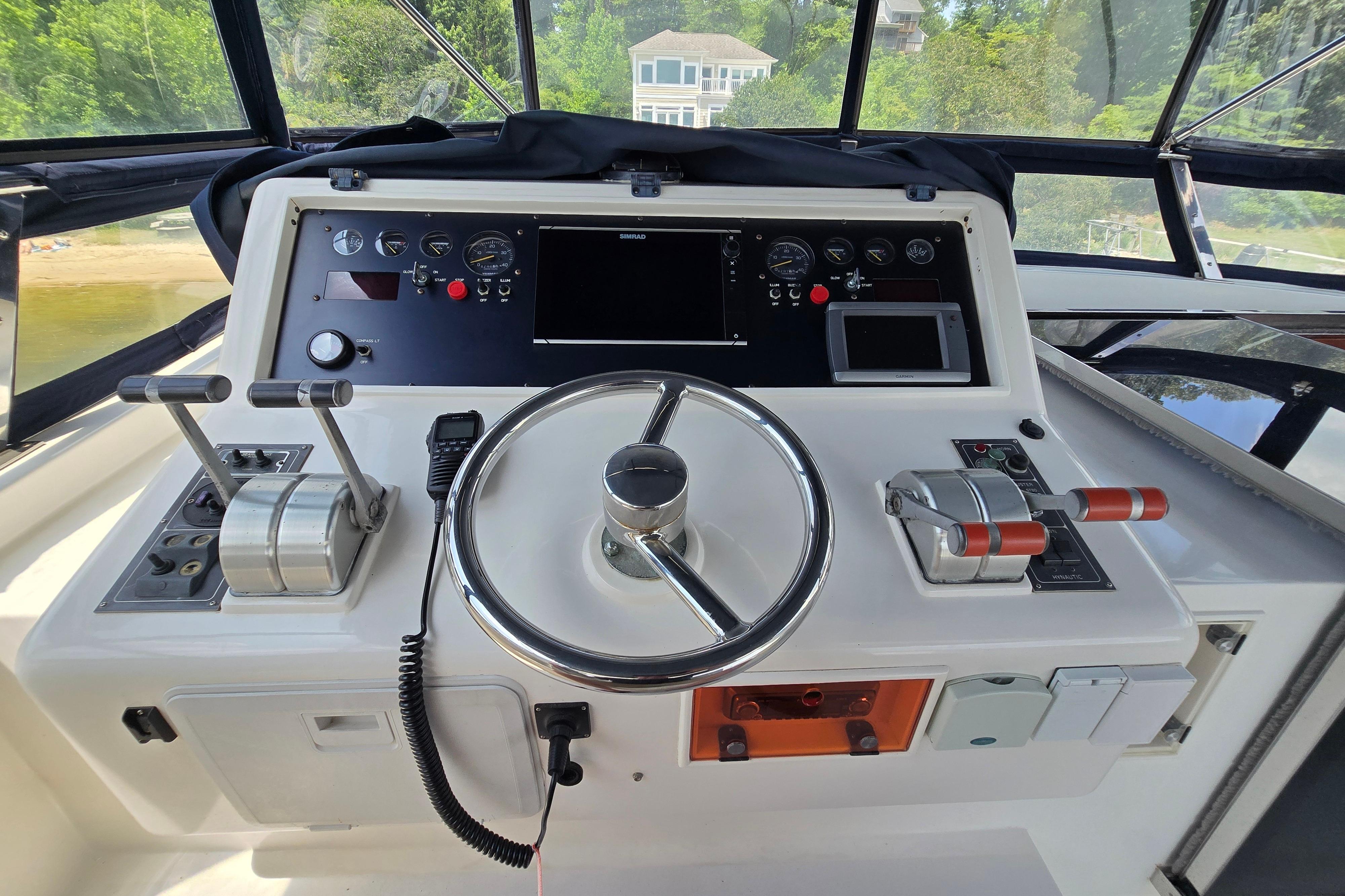 Helm of 2004 Grand Harbour 58 yacht with steering wheel and control panel.