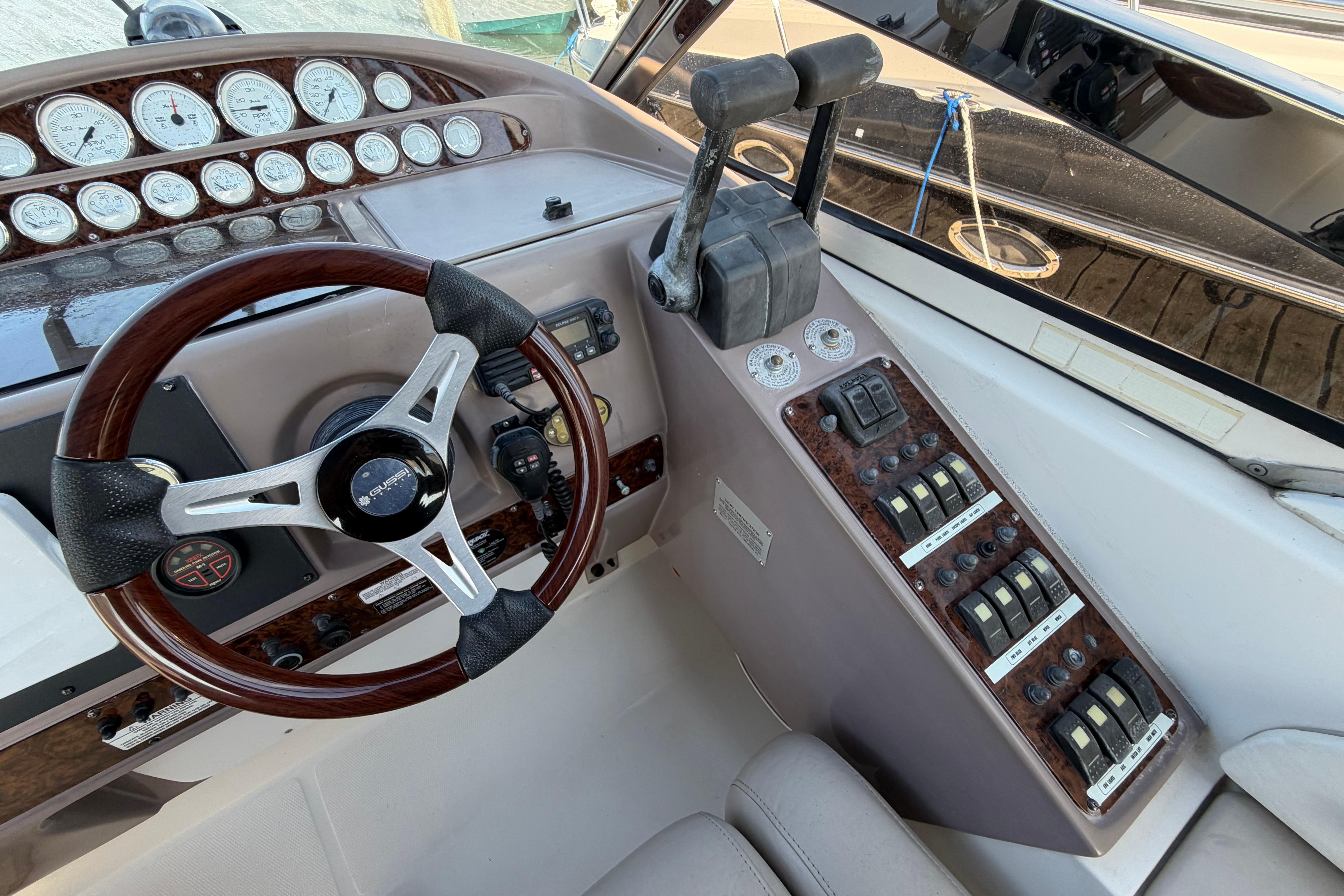 Steering console of a 2003 Regal Commodore 3260 boat with gauges and controls.