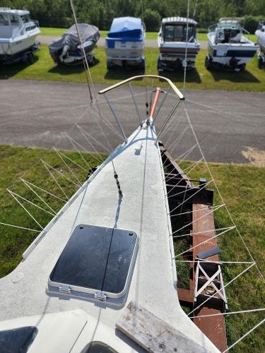1985 Crowther Buccaneer sailboat on trailer, surrounded by other boats in a grassy area.