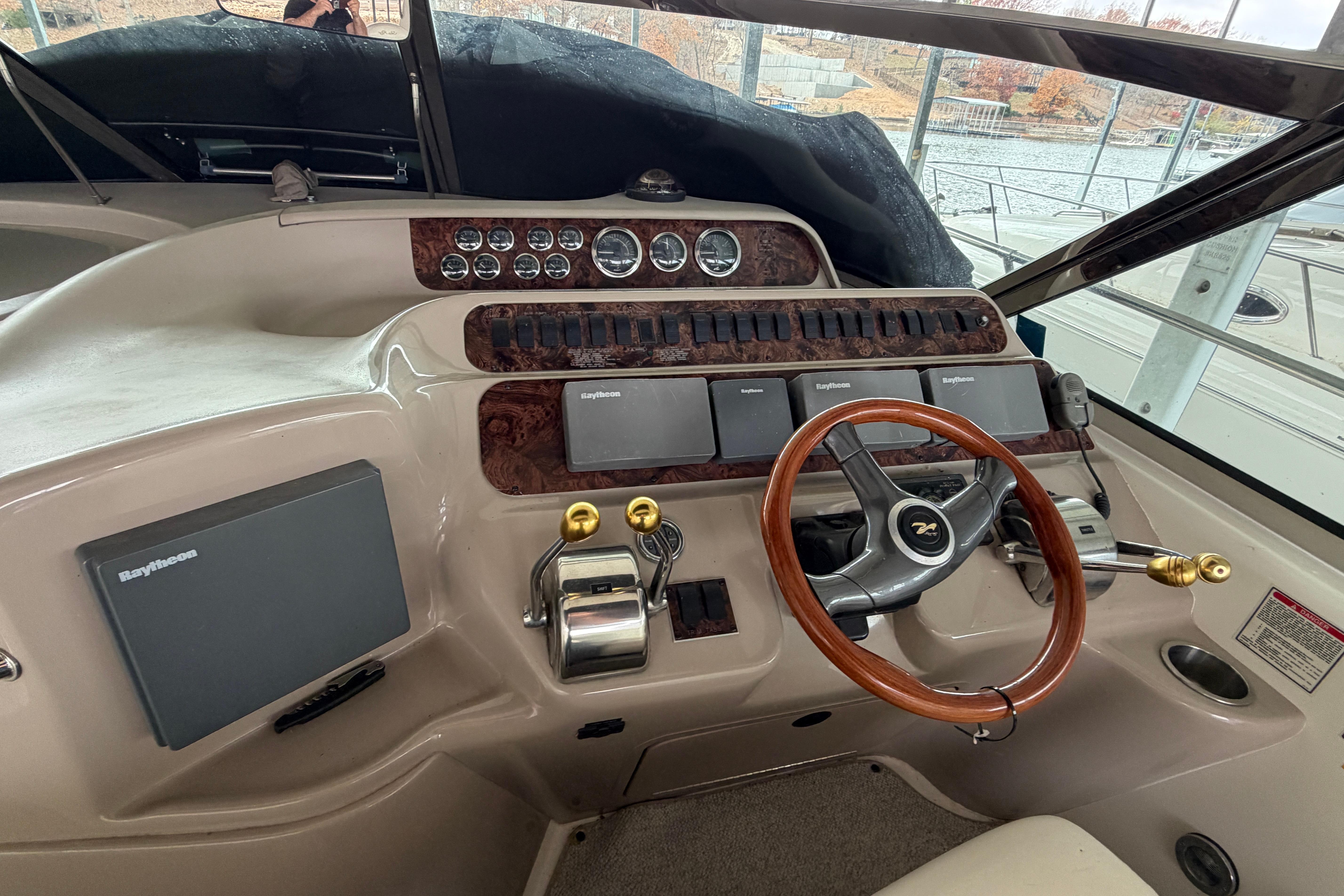 1999 Sea Ray 400 Sundancer helm with wood steering wheel and navigation controls.