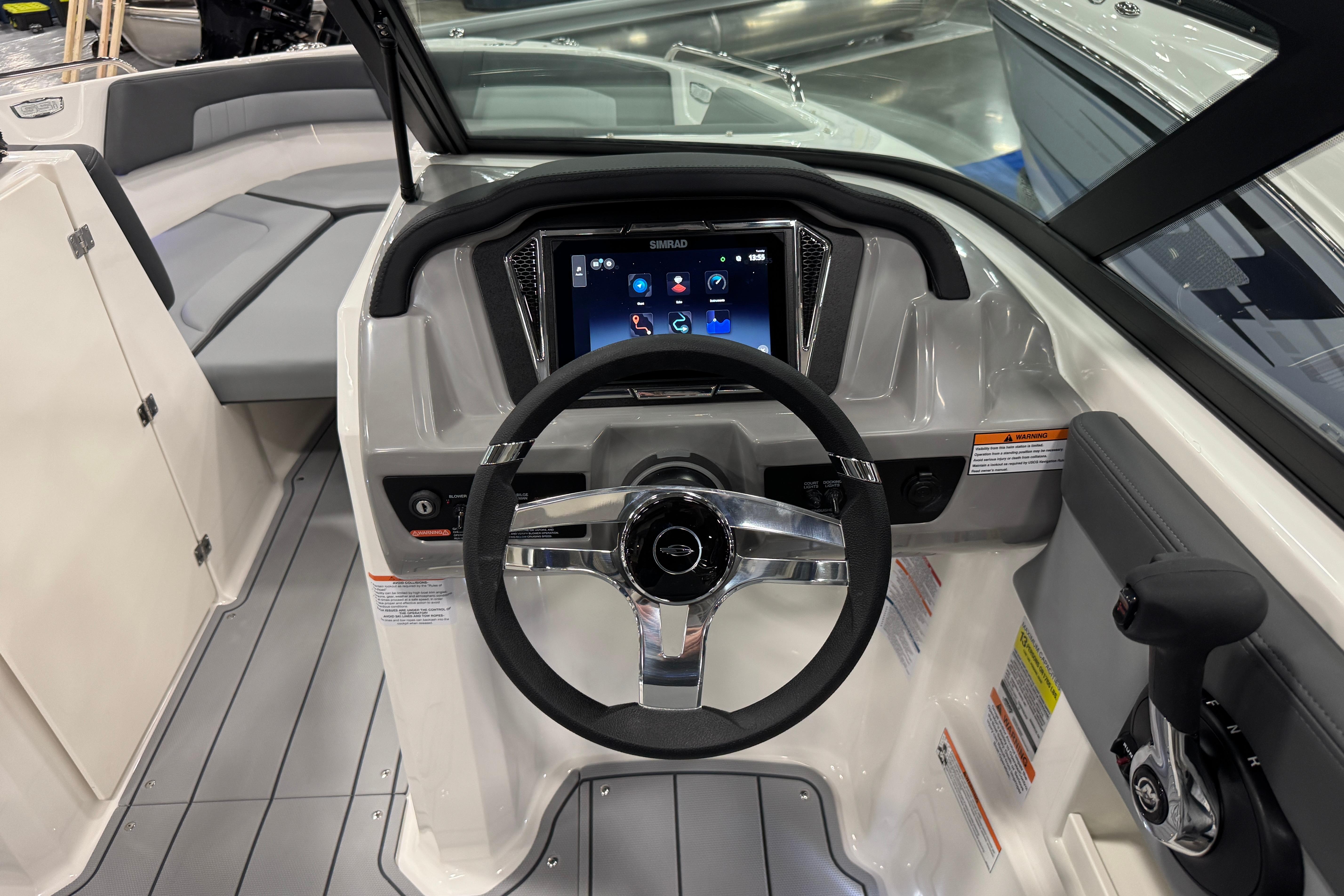 2026 Chaparral 23 SSi boat dashboard with steering wheel and touchscreen display.