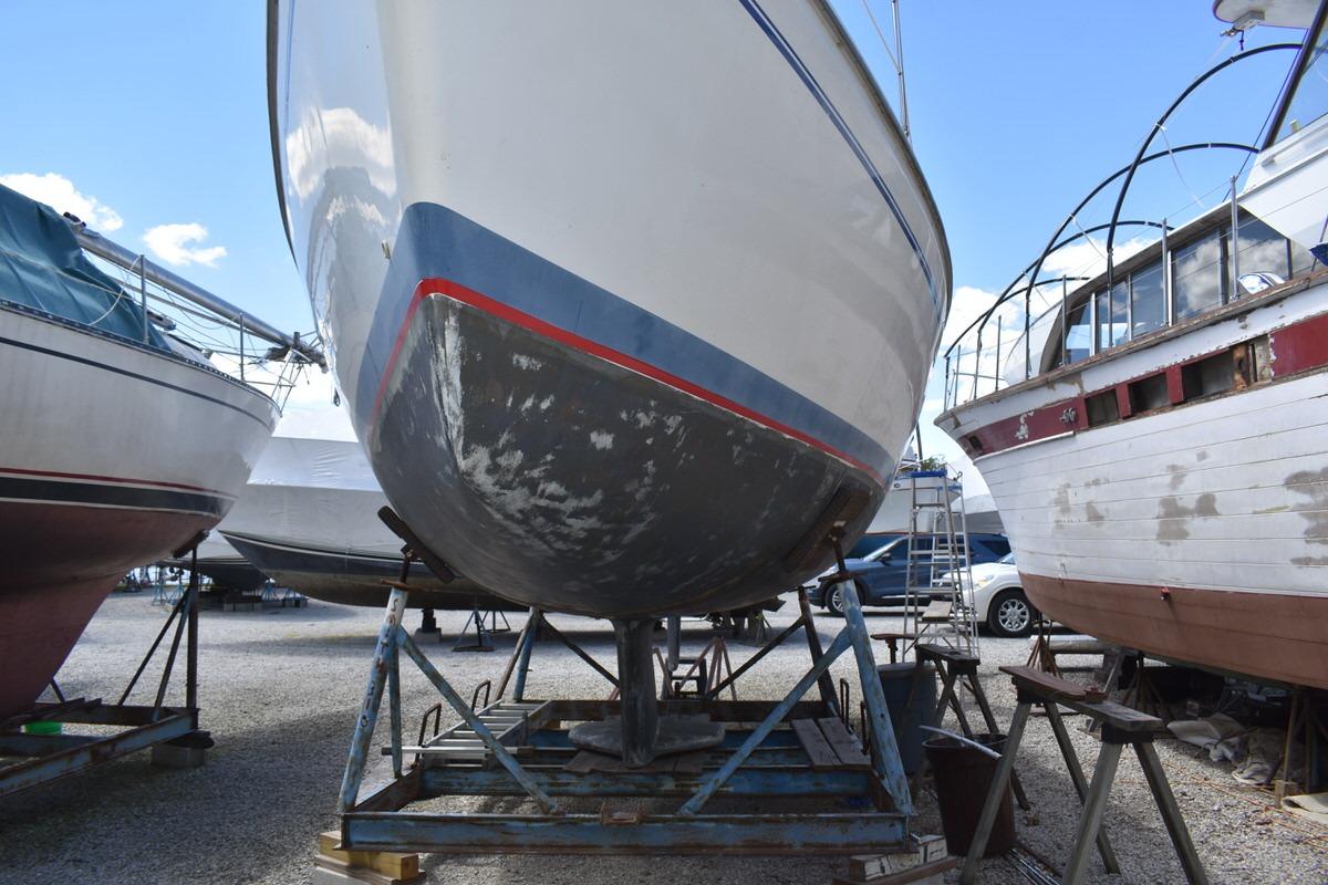 2001 Catalina 310 sailboat on stands in a boatyard, undergoing maintenance.