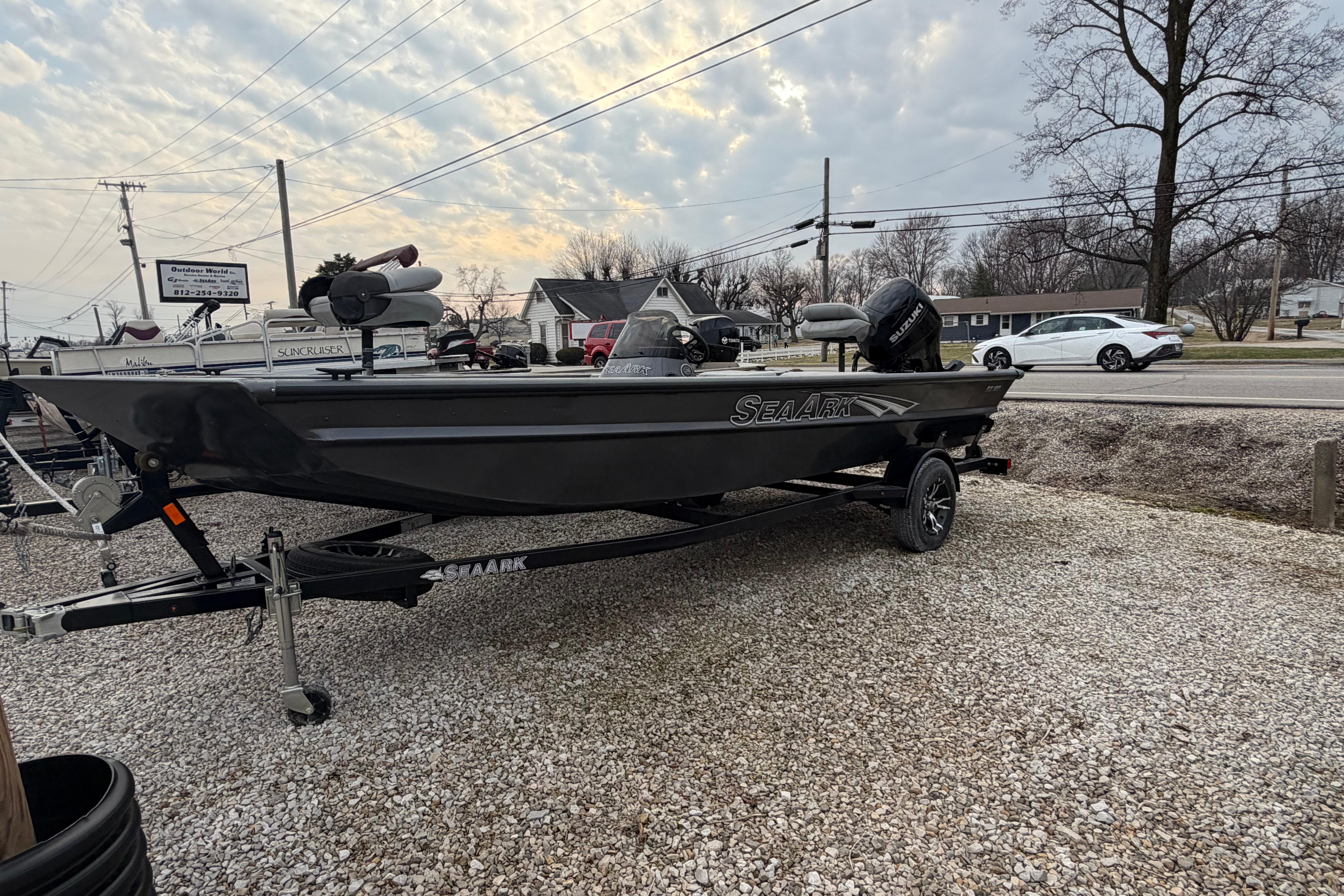2023 SeaArk 180 RX boat on trailer, parked outdoors under cloudy sky.