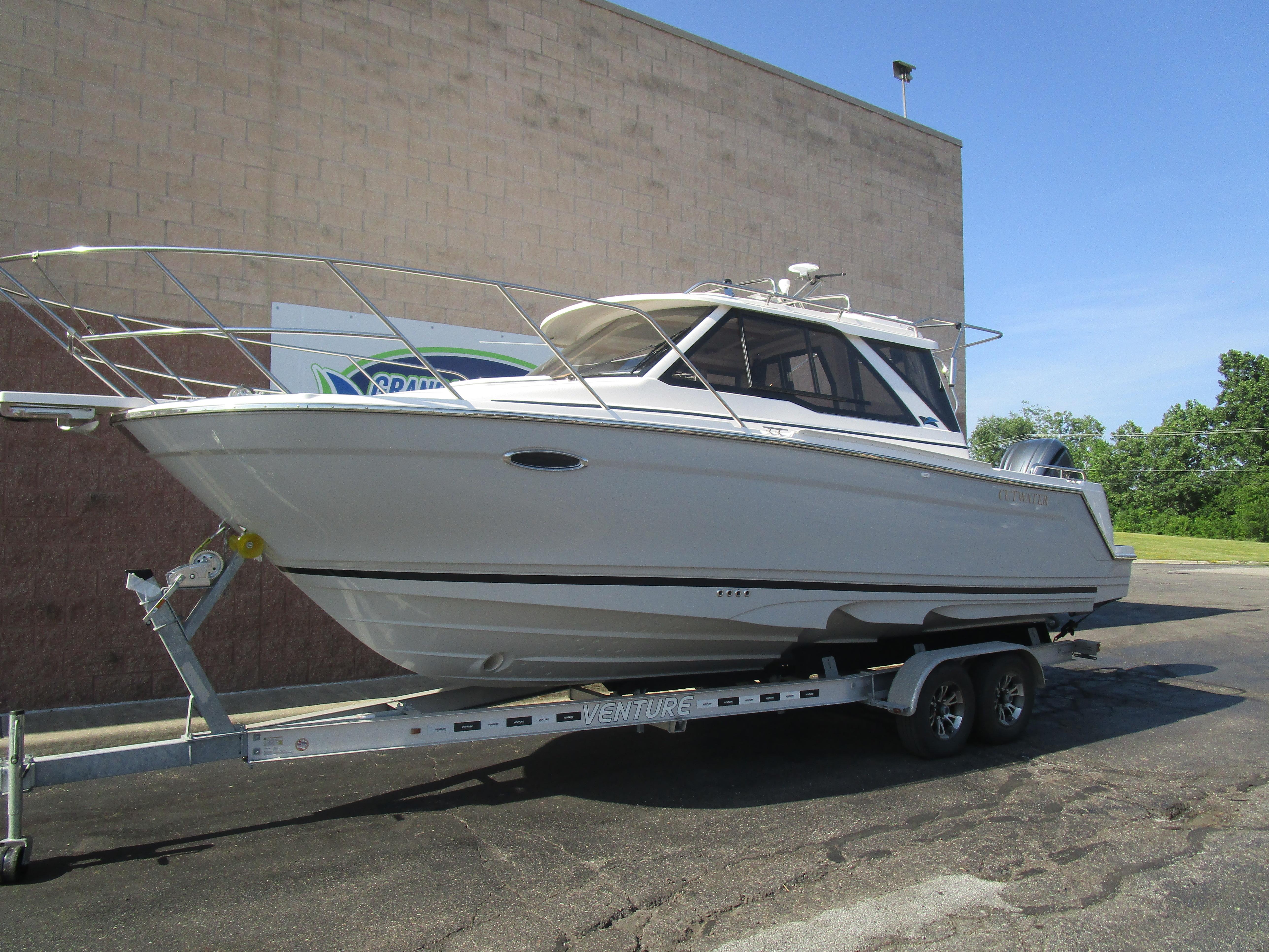 2025 Cutwater C-248 Coupe boat on trailer, parked outdoors.