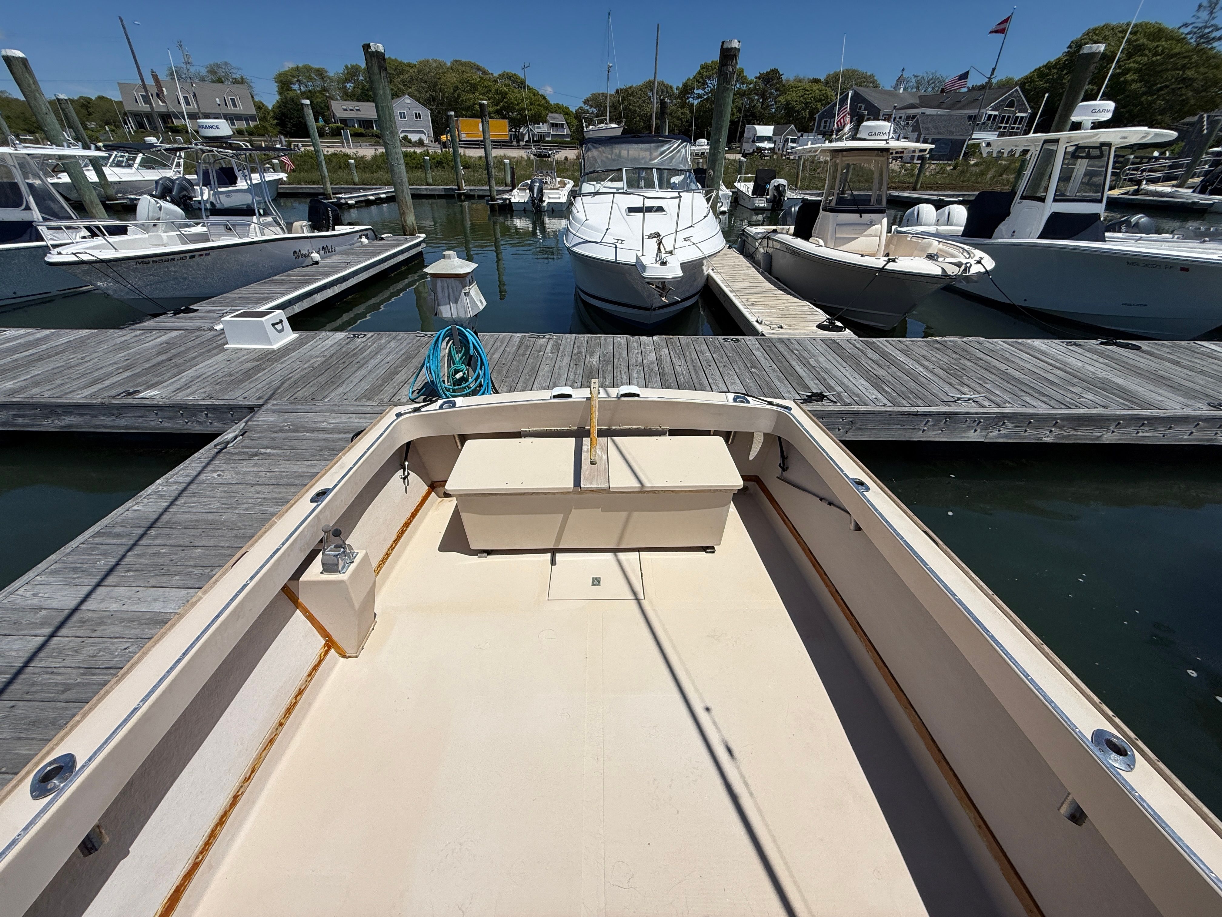 A 1989 Fortier 26 boat docked in a calm marina.
