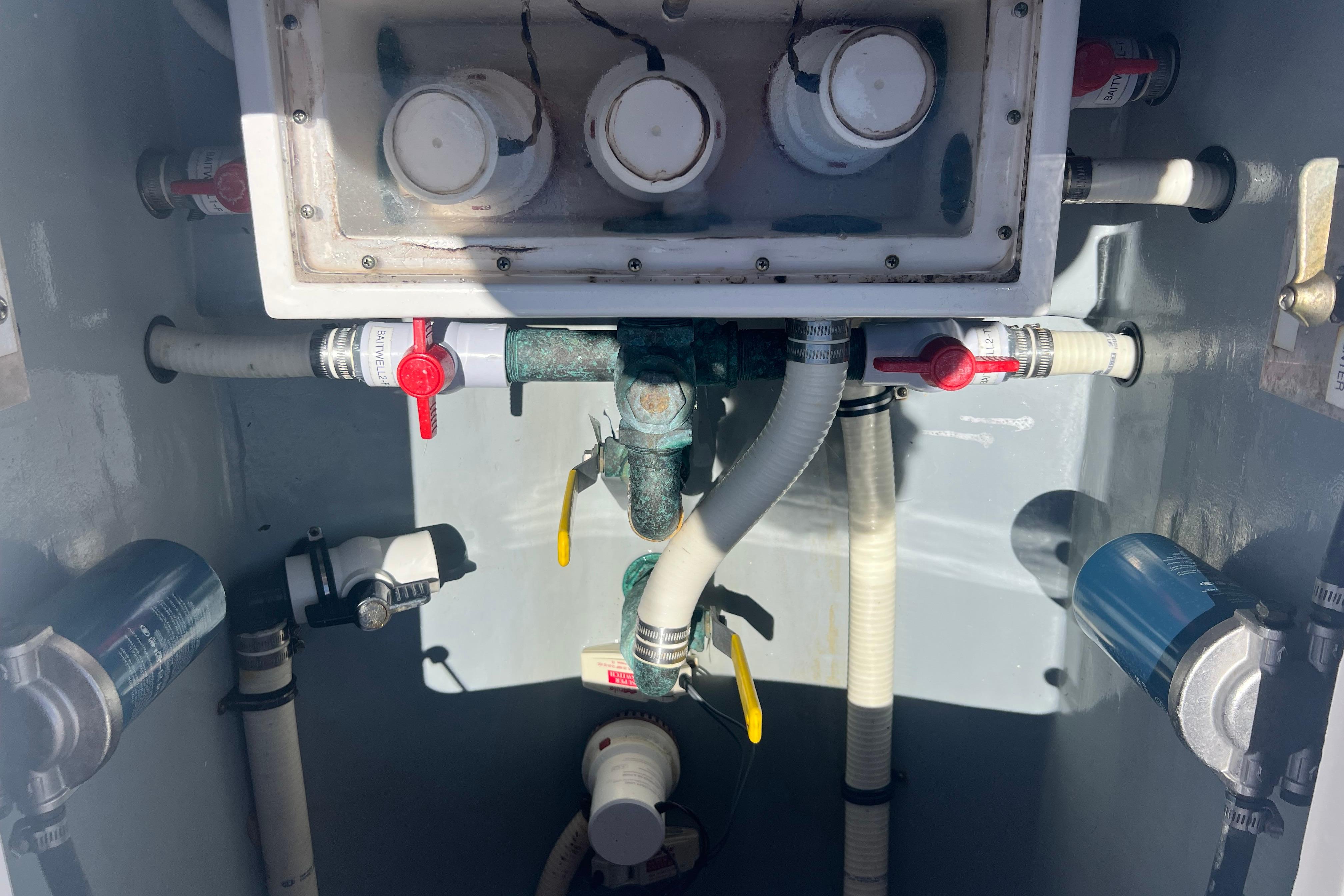 Bilge area of 2012 Invincible 33 Open Fisherman with plumbing and valves.