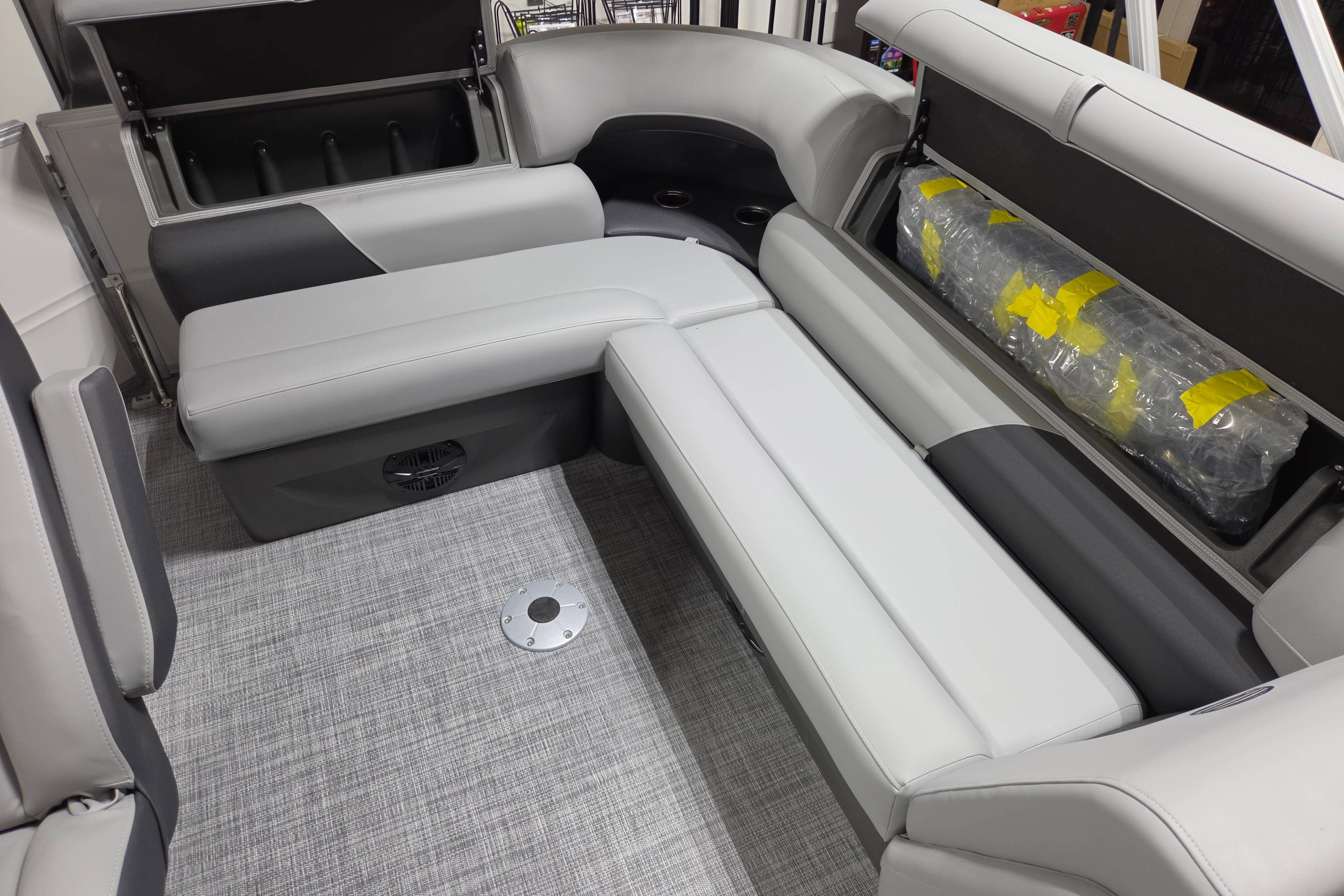 2026 Sun Tracker Party Barge 20 DLX interior seating with storage compartment open.
