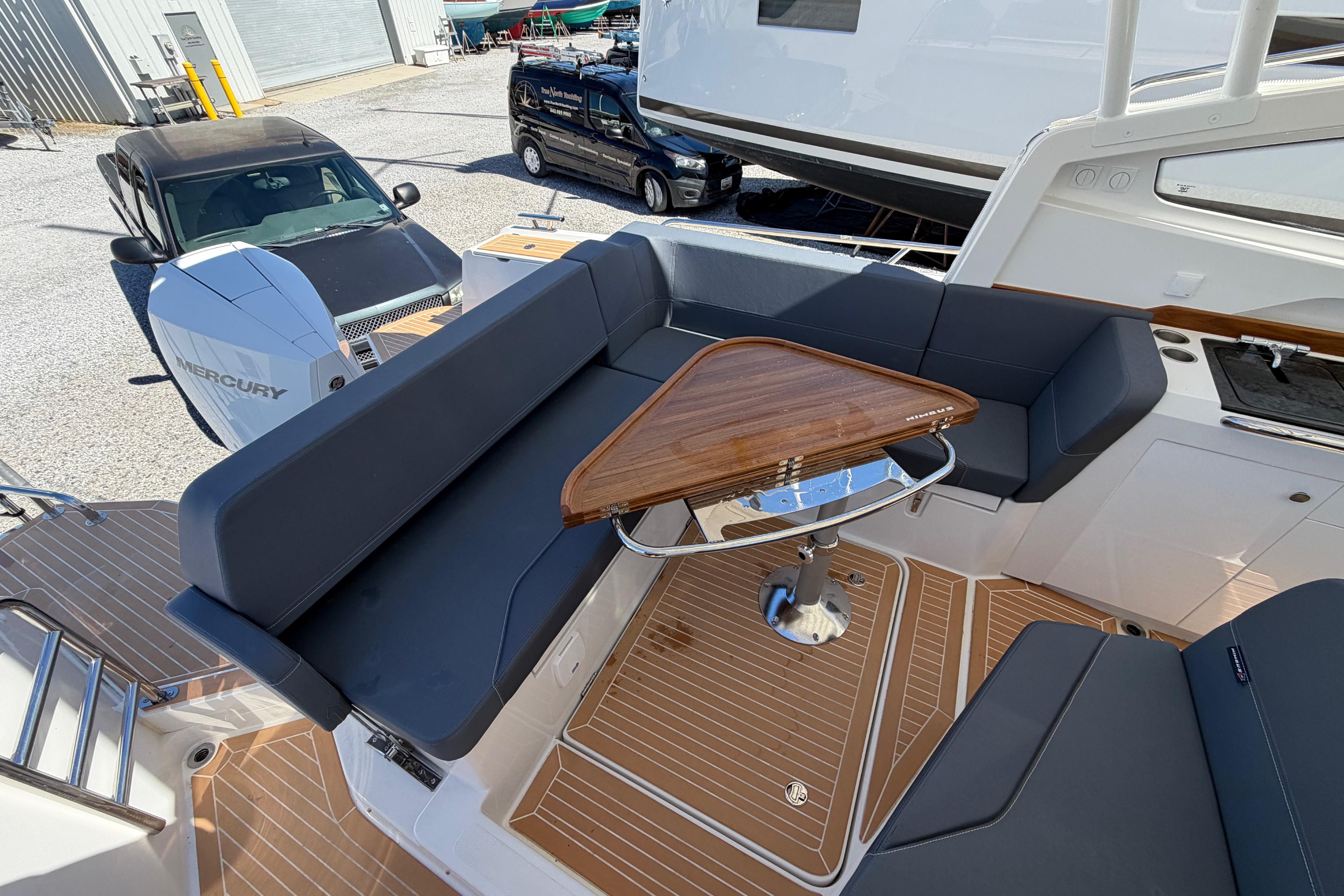 Luxurious seating area on 2025 Nimbus Weekender 9 boat with wooden table and modern design.
