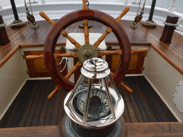 Wooden ship wheel and compass on 1983 Custom Murray Peterson Coaster III sailboat.