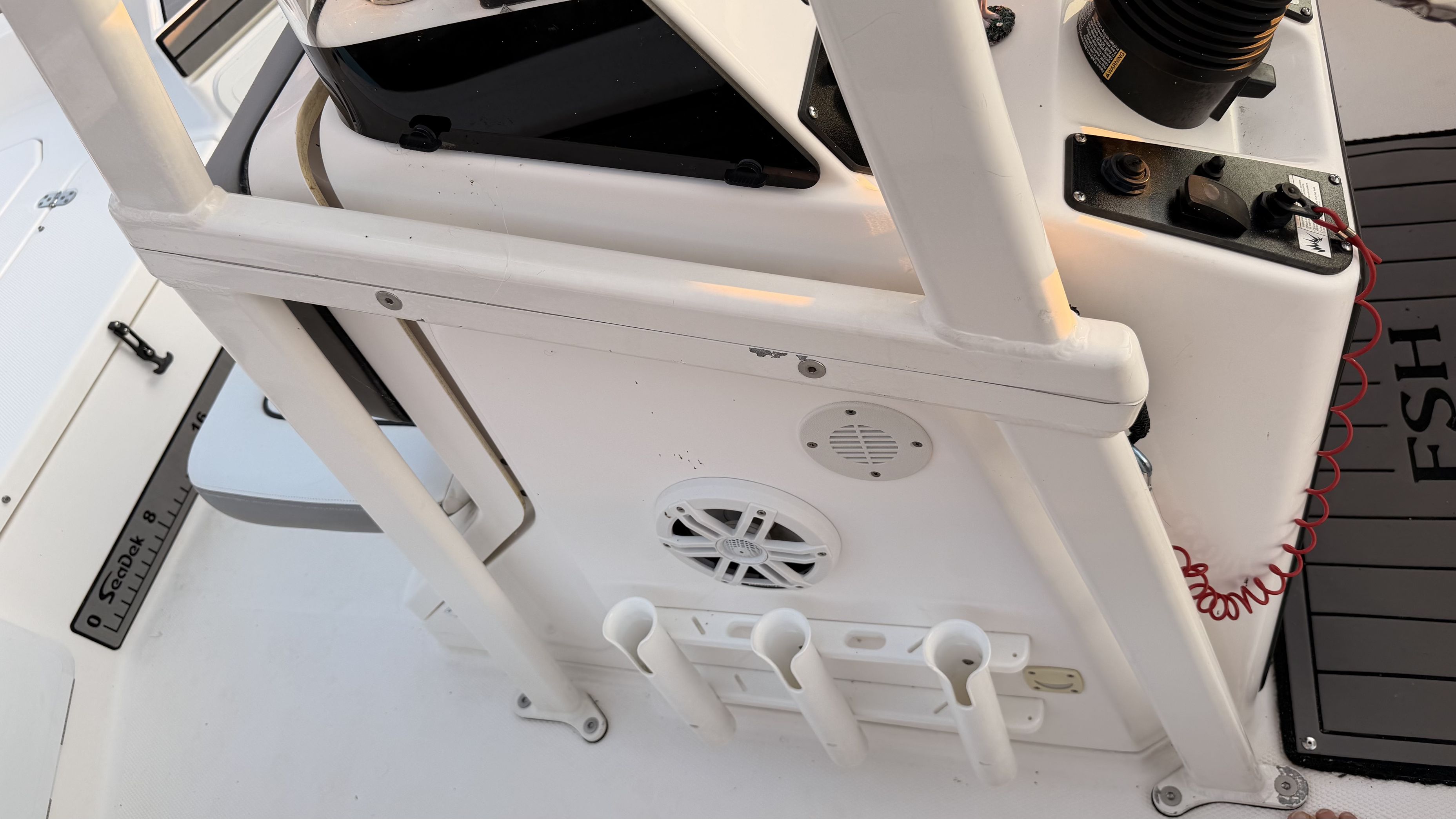 Close-up of a Yamaha 190 FSH Sport boat's helm area with fishing rod holders.