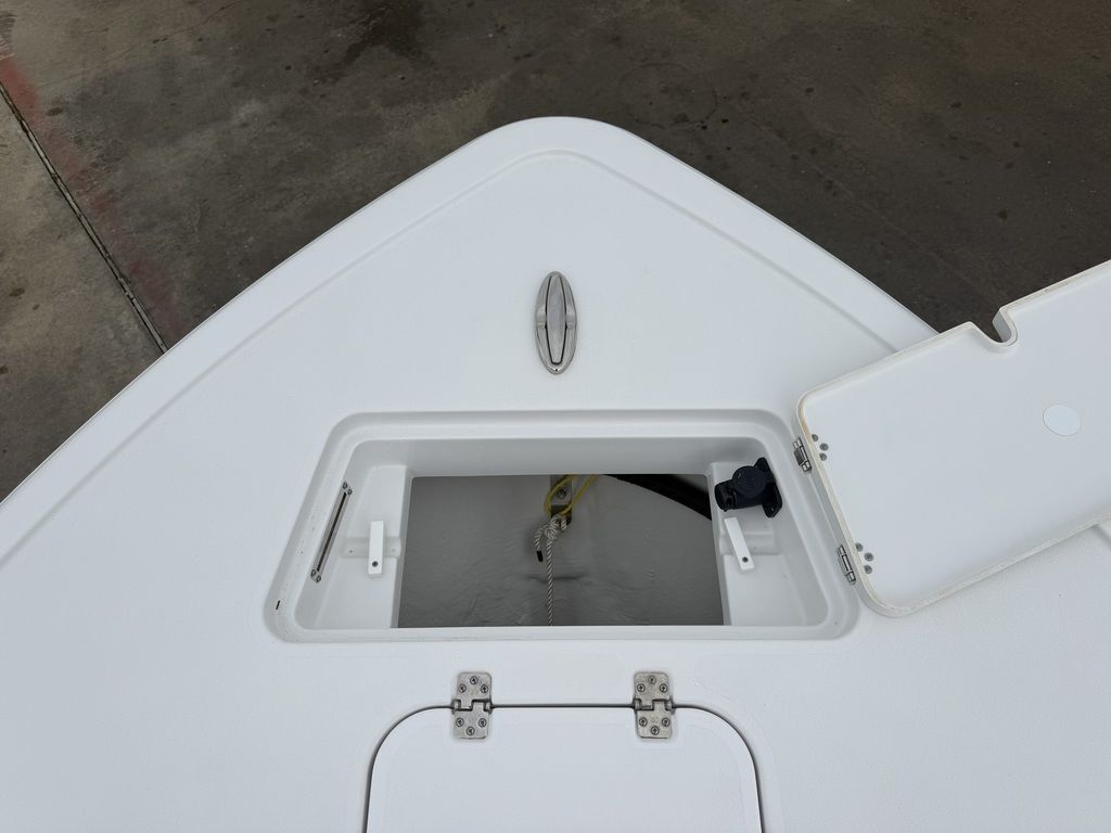 Bow deck of a Sportsman Masters 247OE Bay Boat with an open storage compartment.