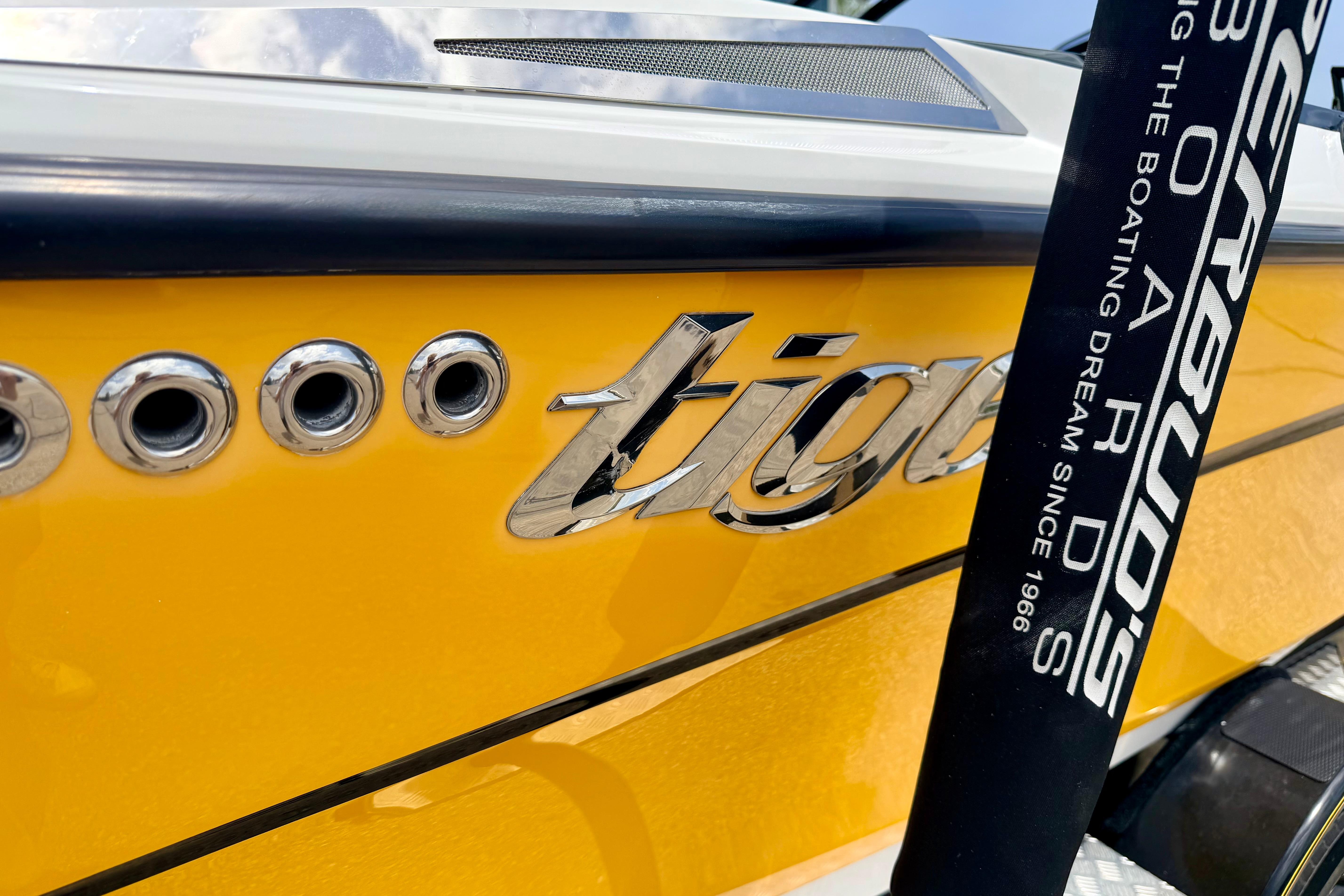 Close-up of 2014 Tigé R20 boat with yellow hull and chrome logo.
