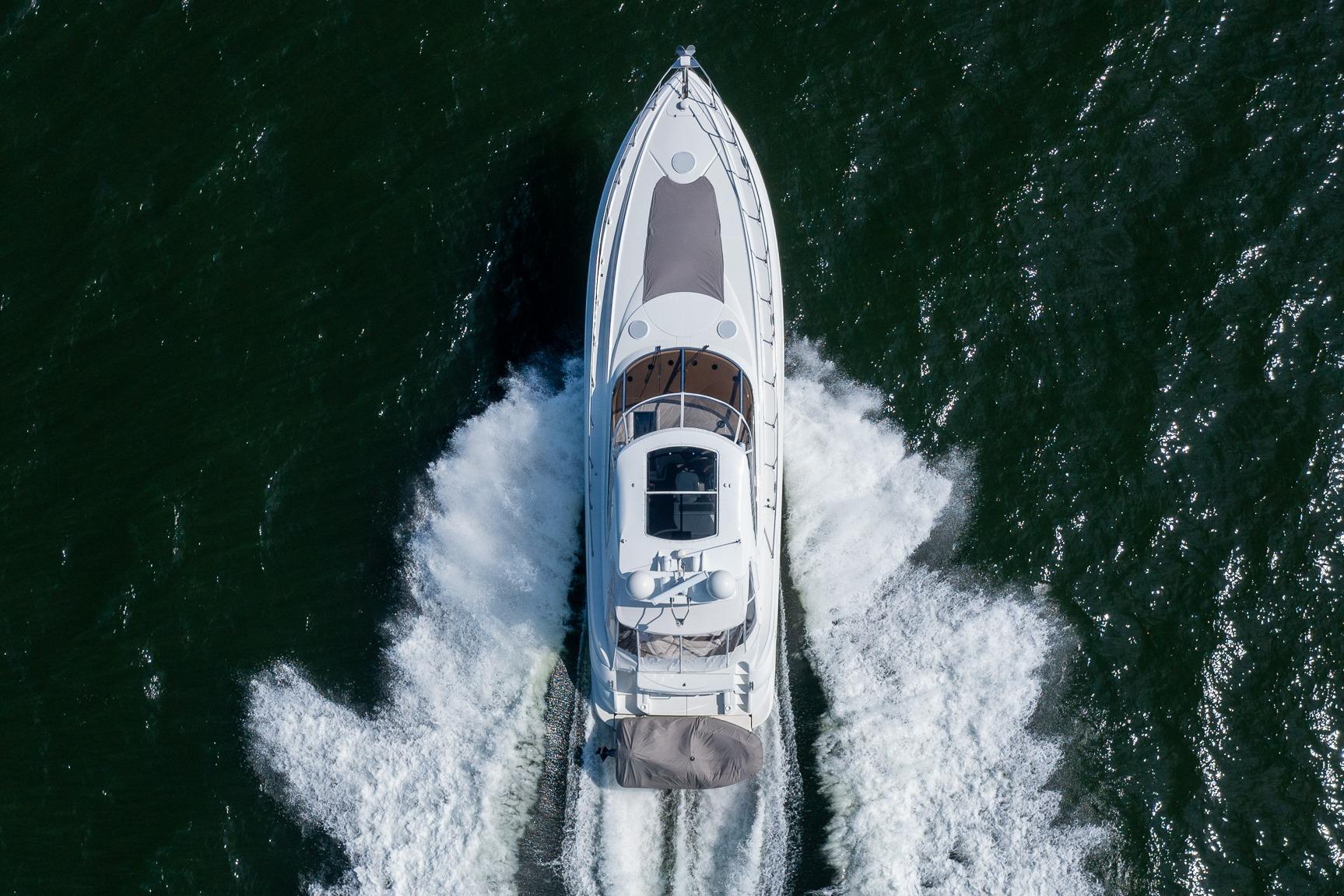 Aerial view of 2002 Cruisers 5370 yacht cruising on open water.