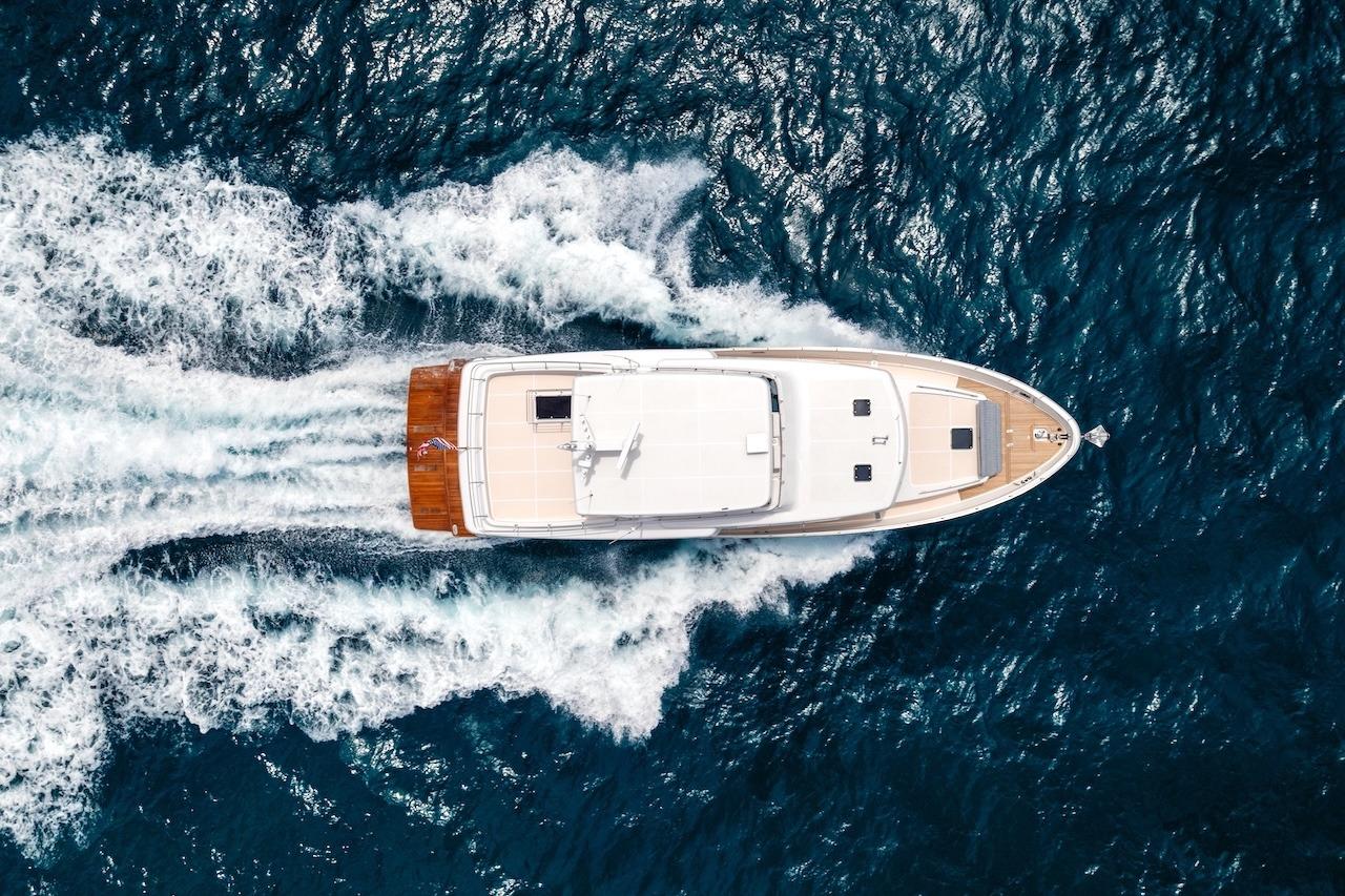 Aerial view of 2027 Offshore Yachts 70 CE cruising through ocean waves.