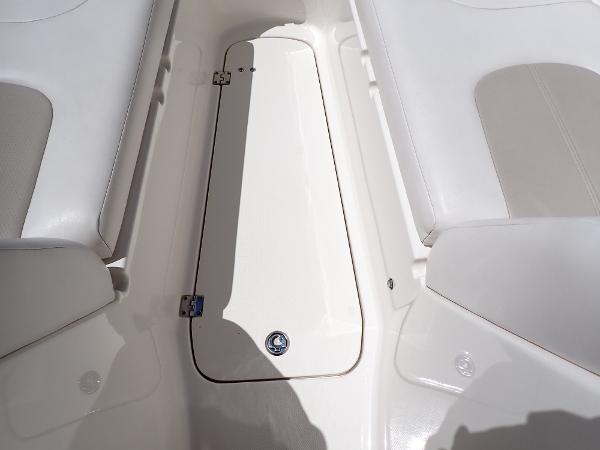 Interior view of 2011 Chaparral 287 SSX boat, featuring white seating and storage compartment.