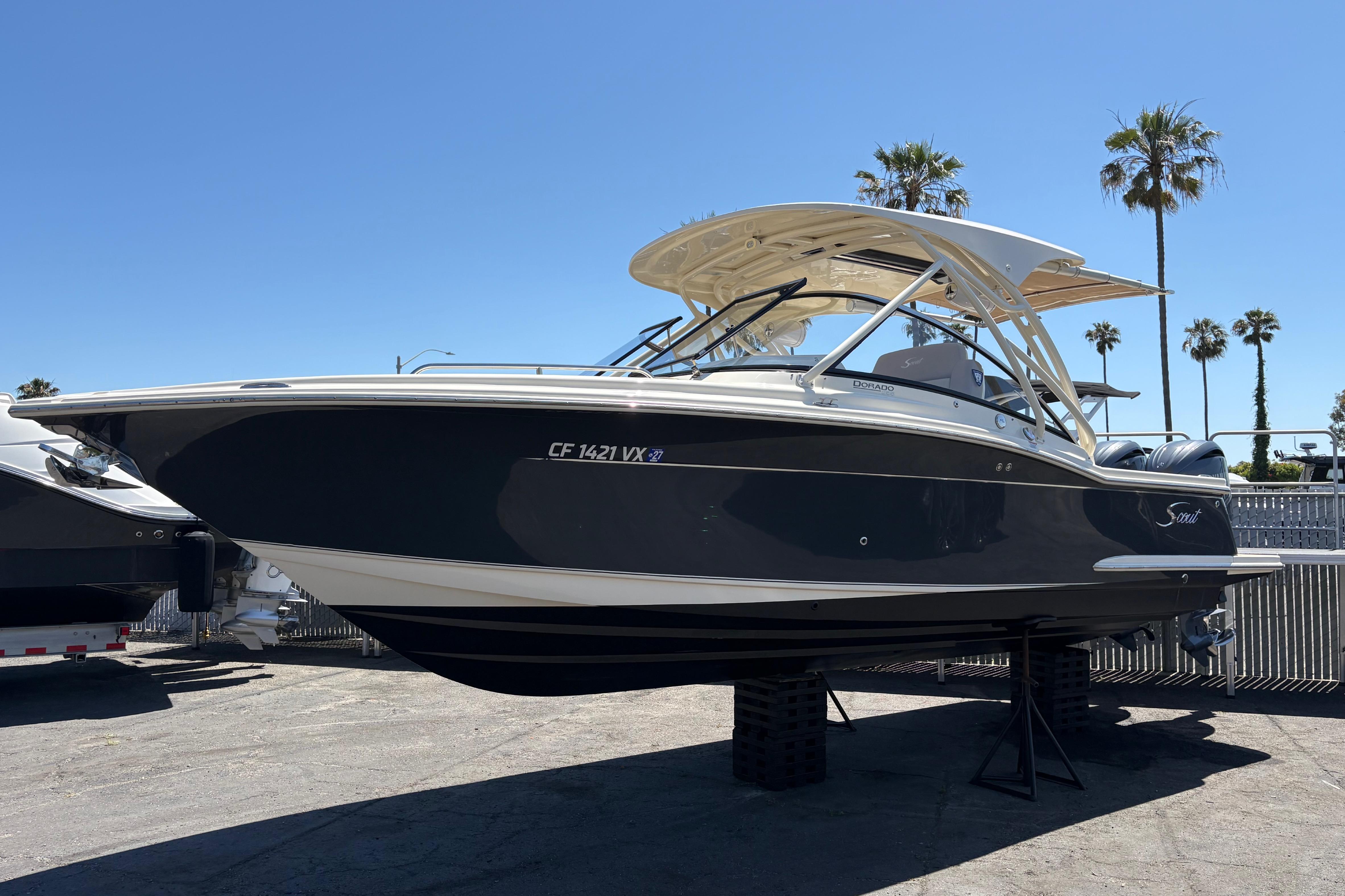2024 Scout 255 Dorado boat displayed outdoors with palm trees in the background.