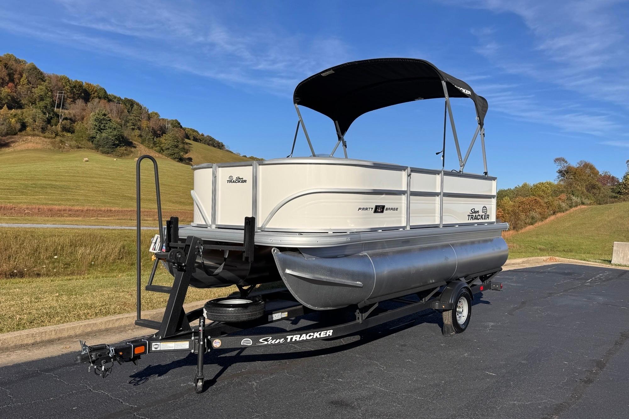 2026 Sun Tracker Party Barge 16 DLX pontoon boat on trailer, scenic background.