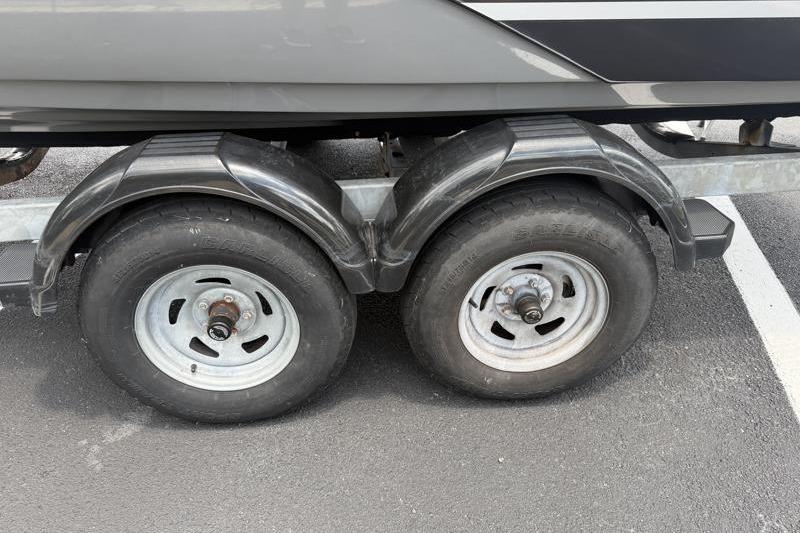 Trailer wheels of a 2017 Yamaha Boats SX210 on asphalt parking lot.
