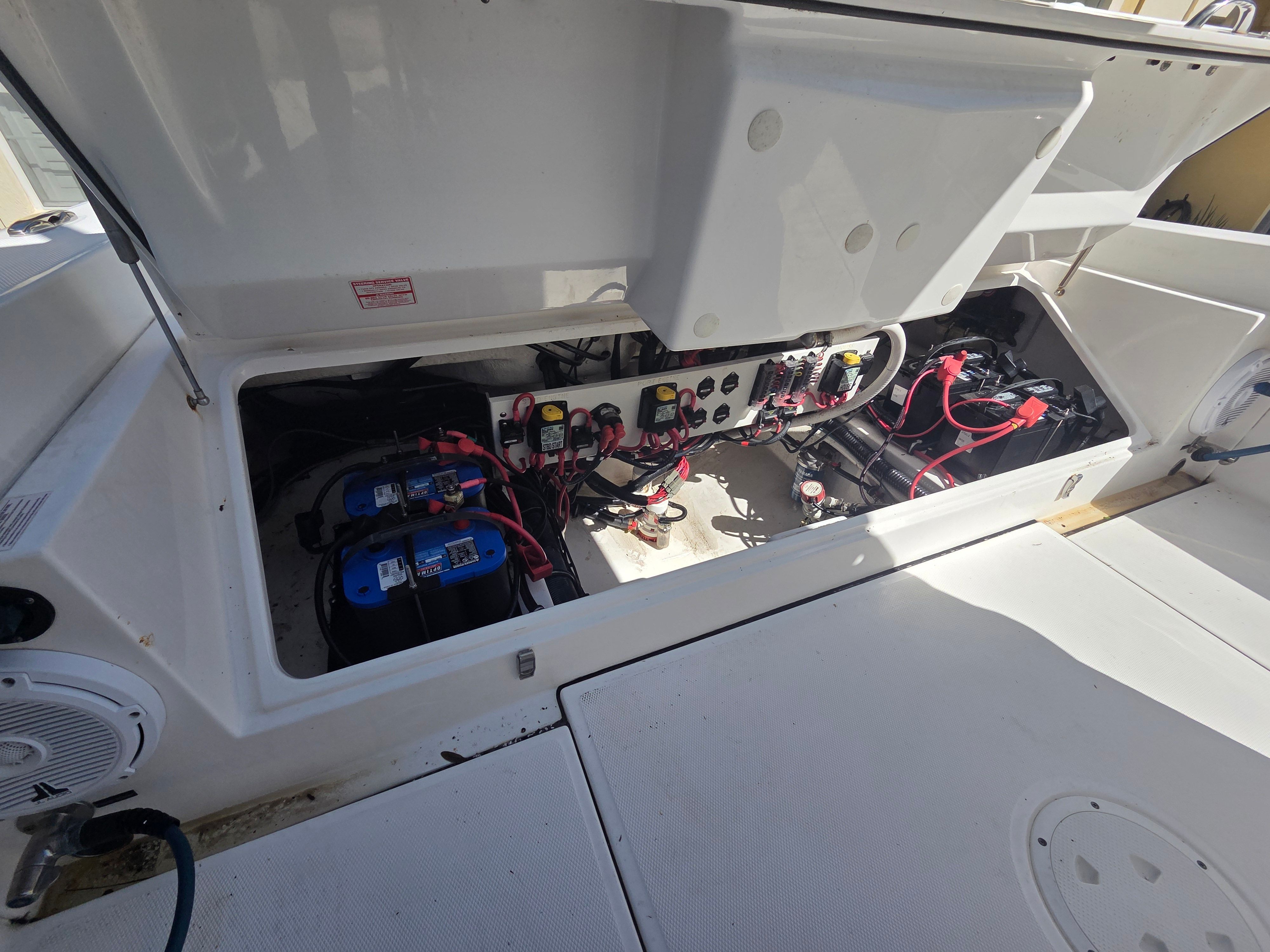 The image shows the engine compartment of a 2017 Everglades 273 Center Console boat with batteries and wiring.
