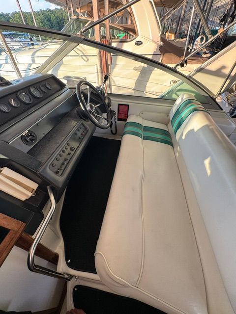 The cockpit of a 1992 Sea Ray 290 Sundancer with white seating and a green stripe.