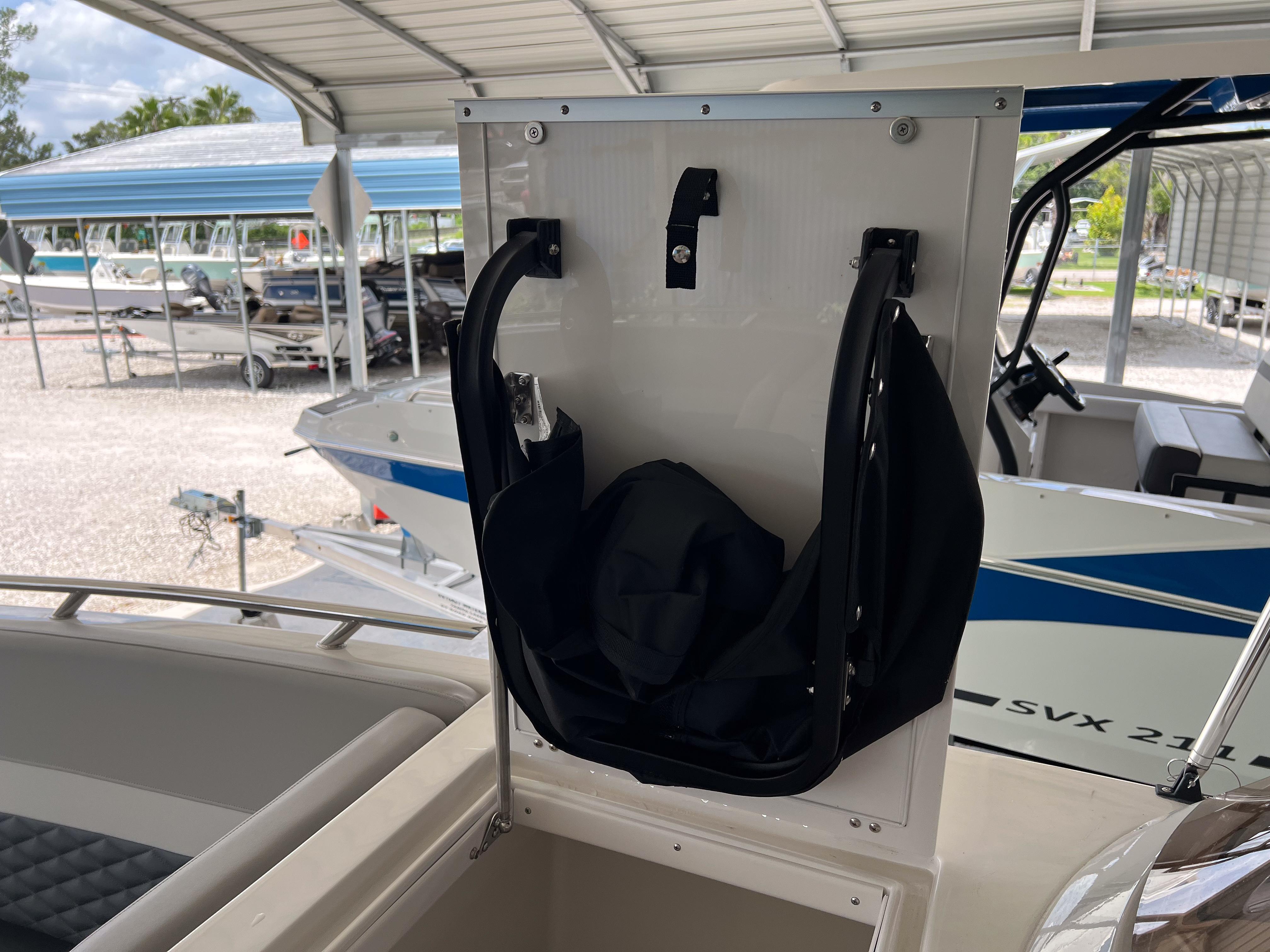 2026 Starcraft SVX 231 OB boat storage compartment with black bag under covered dock.