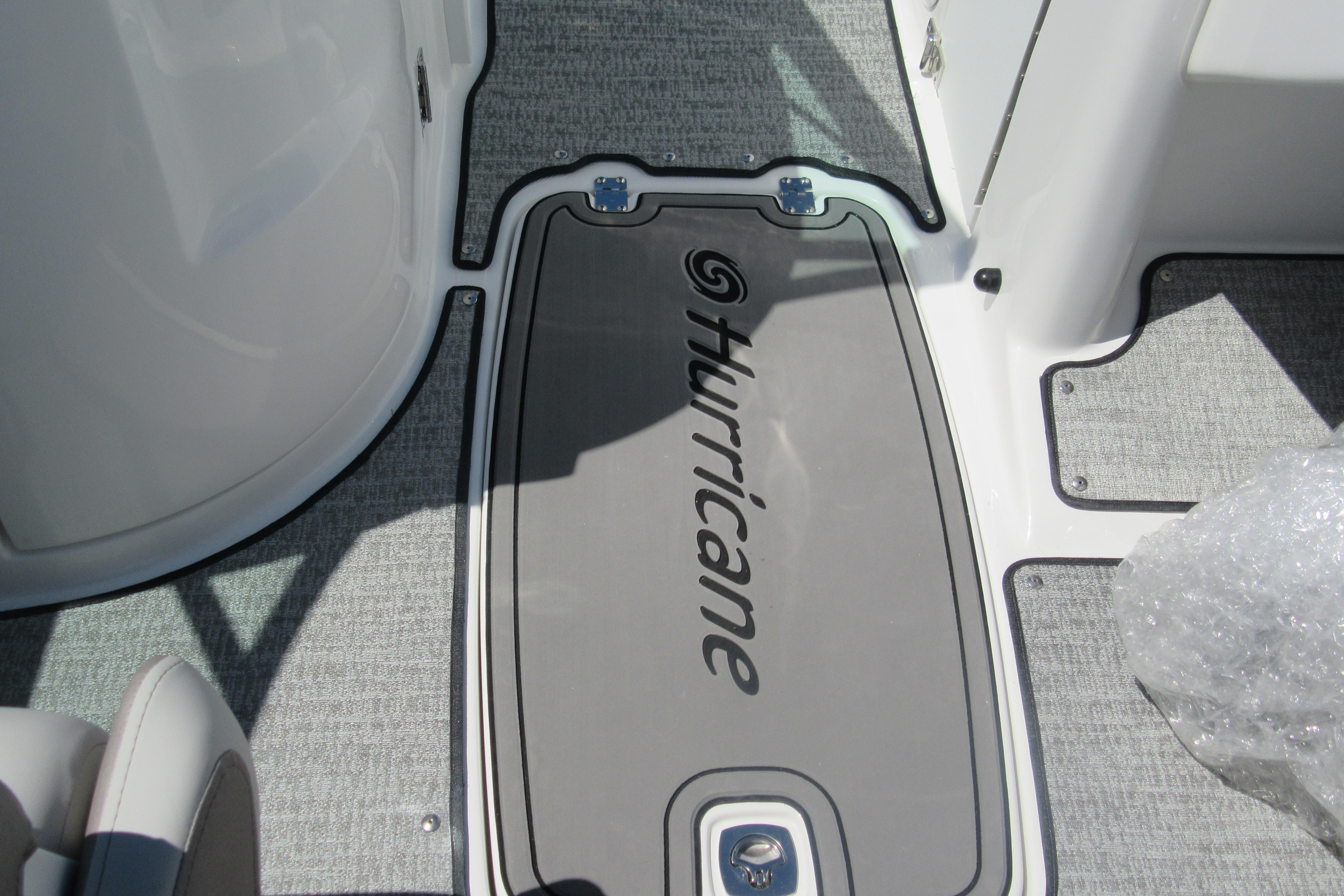 Interior view of 2027 Hurricane SunDeck 2486 OB boat, featuring branded flooring.