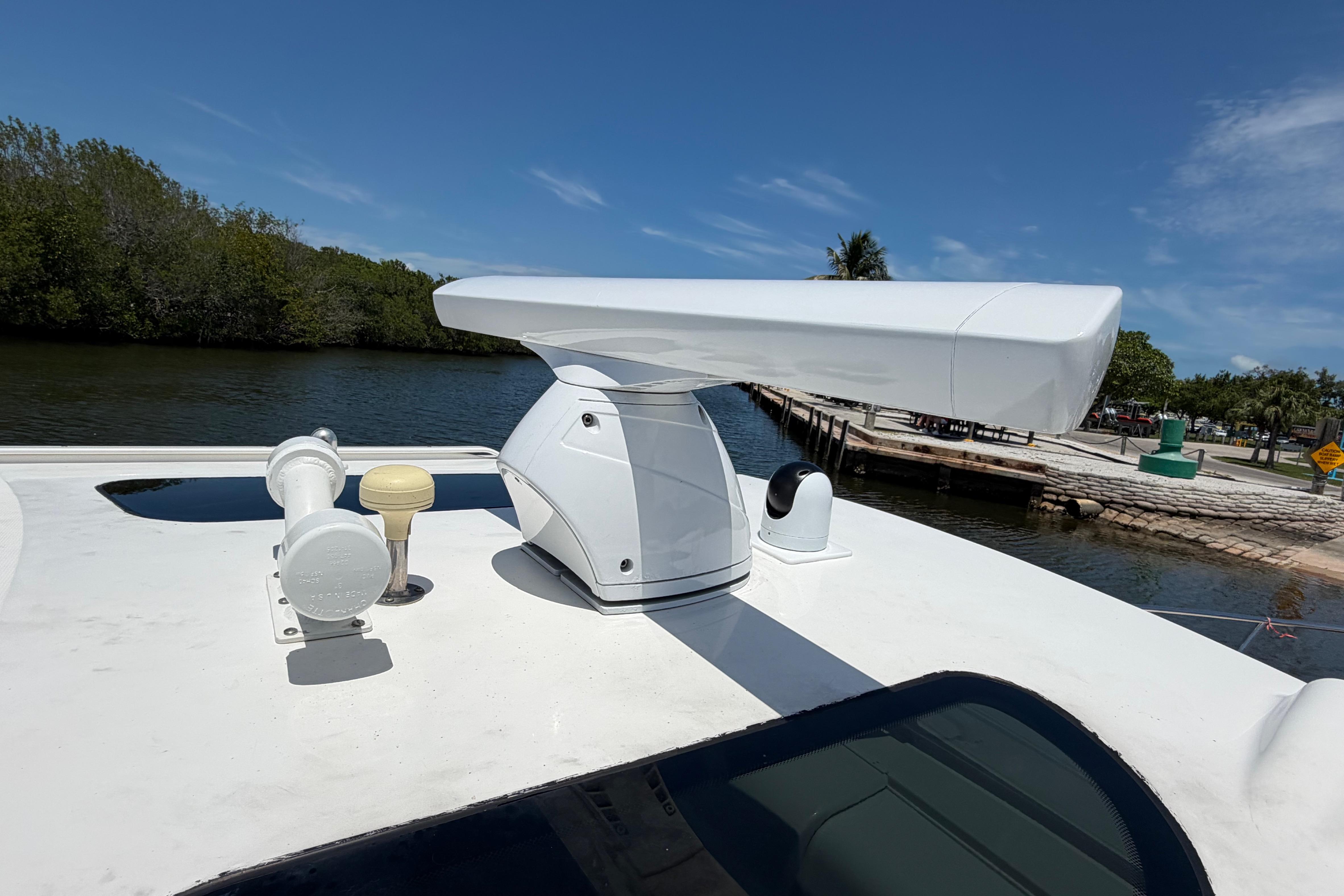 Radar equipment on 2009 Everglades 350LX boat, docked by a scenic waterway.