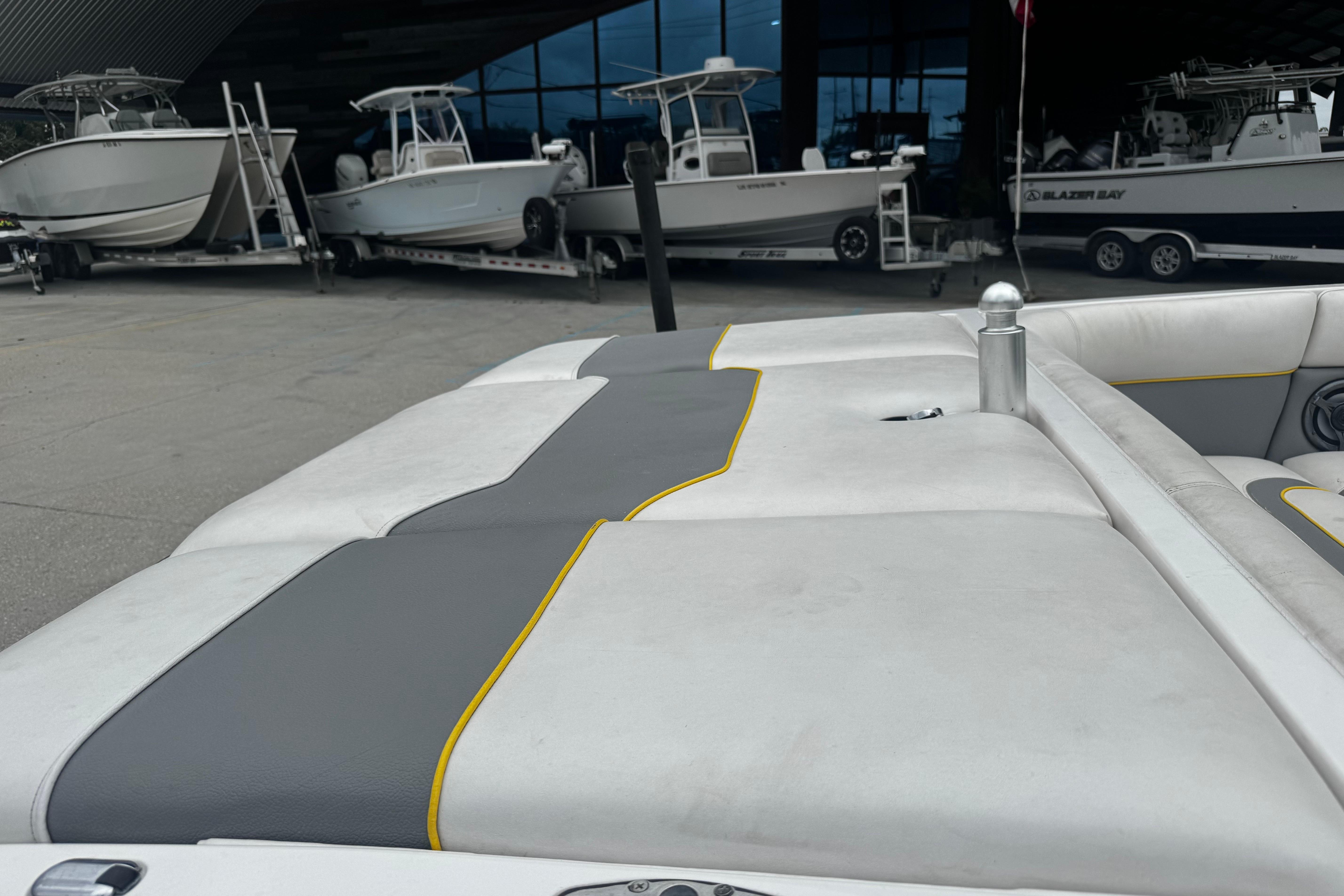 2006 Supra Launch 22 SSV boat interior with gray and yellow accents, docked near other boats.