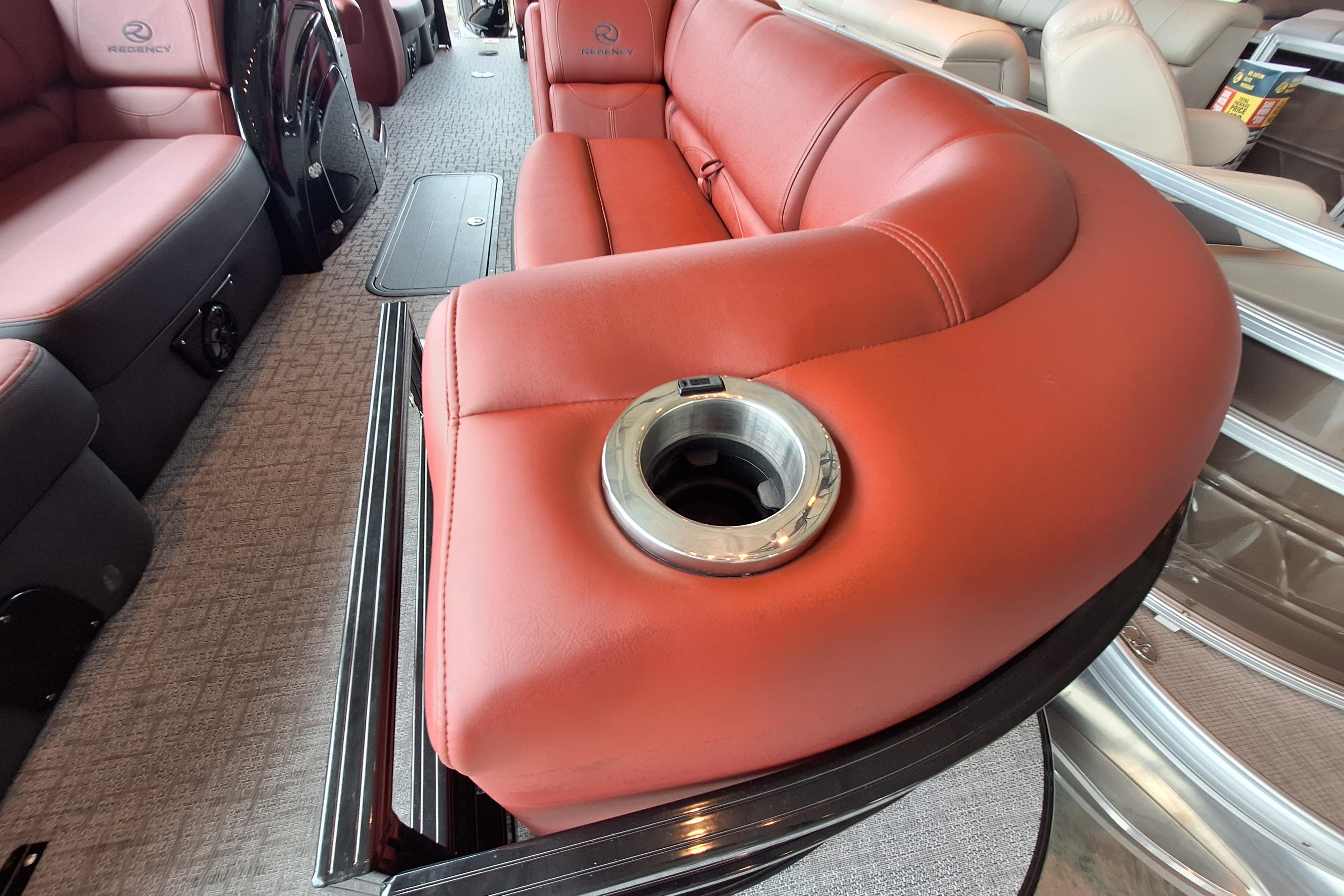 Luxurious red seating with cup holder in 2026 Regency 230 DL boat interior.