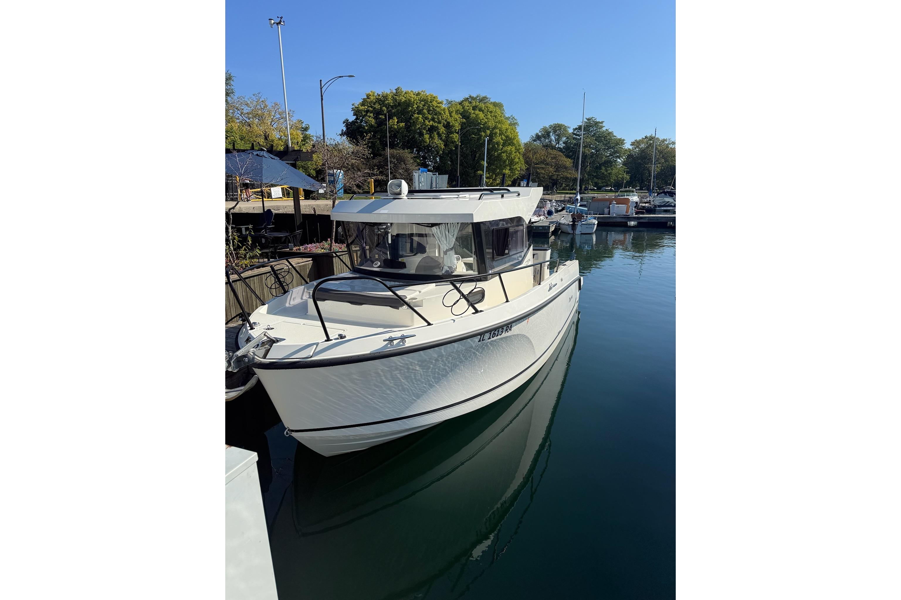 2024 Bayliner Trophy T25 Pilothouse boat docked in a serene marina setting.