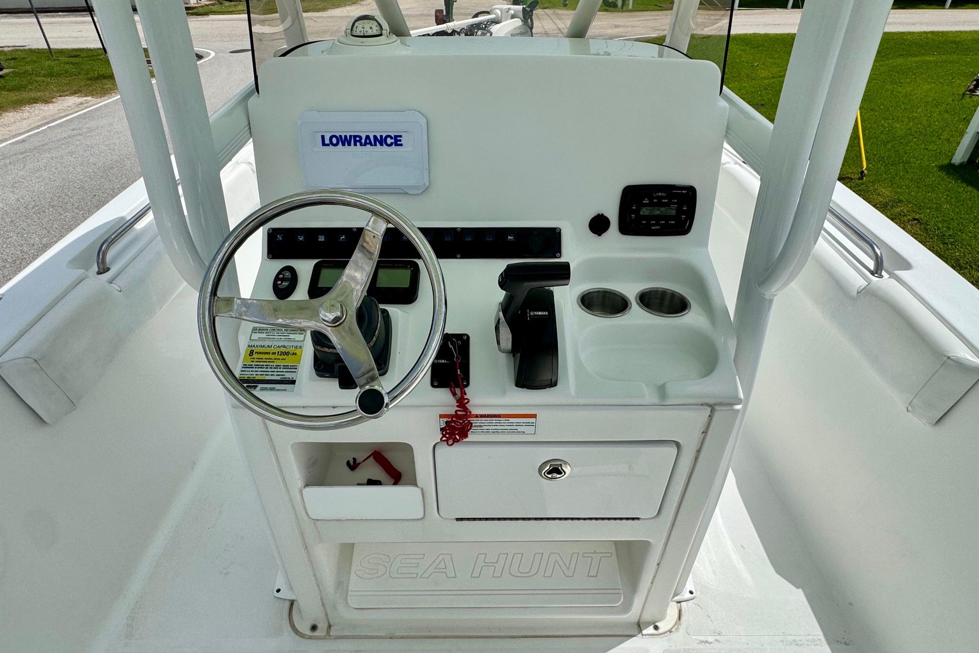 Center console of a 2015 Sea Hunt Ultra 234 boat with steering wheel and controls.