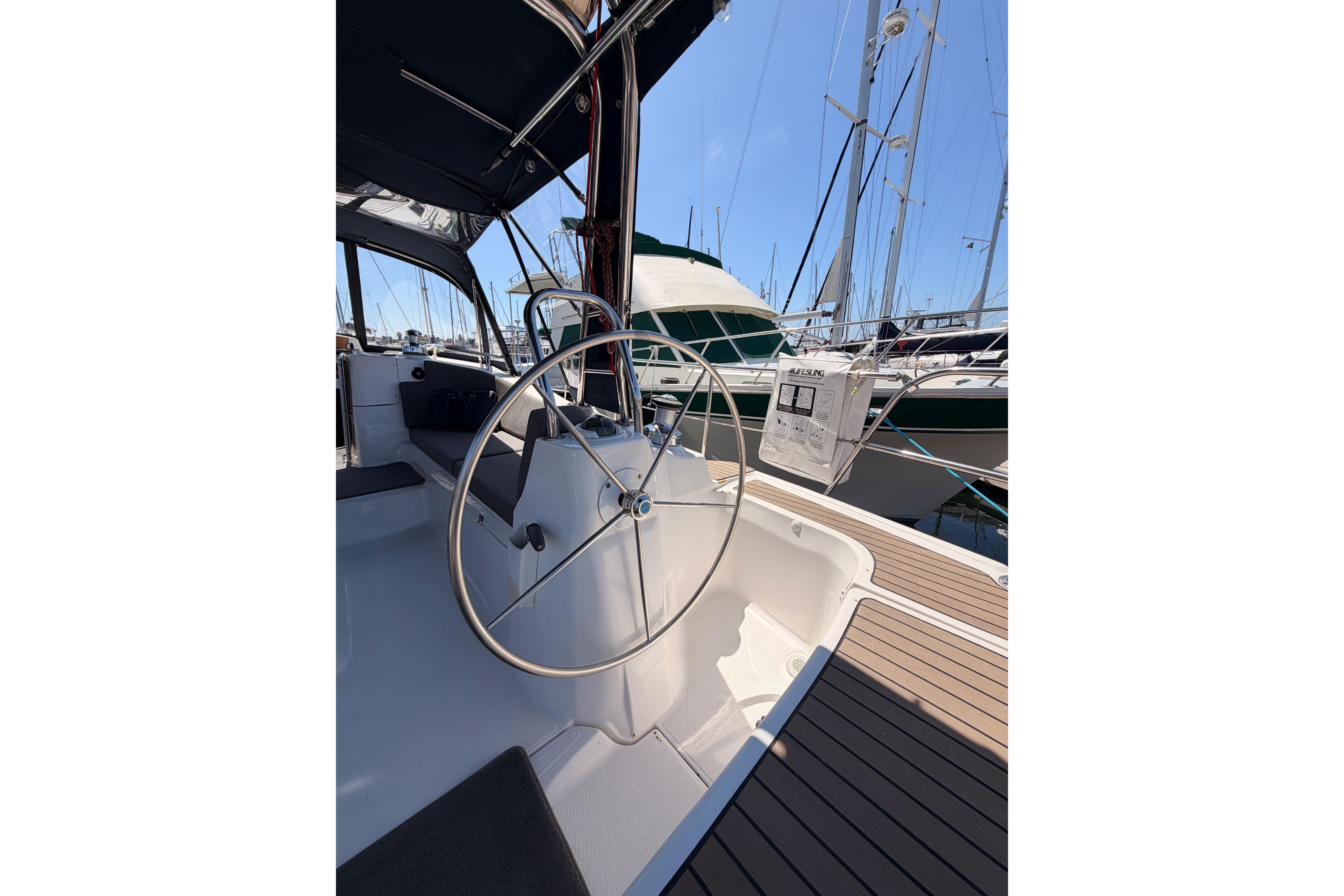 2008 Hunter 45 Deck Salon yacht cockpit with steering wheel, docked at marina.