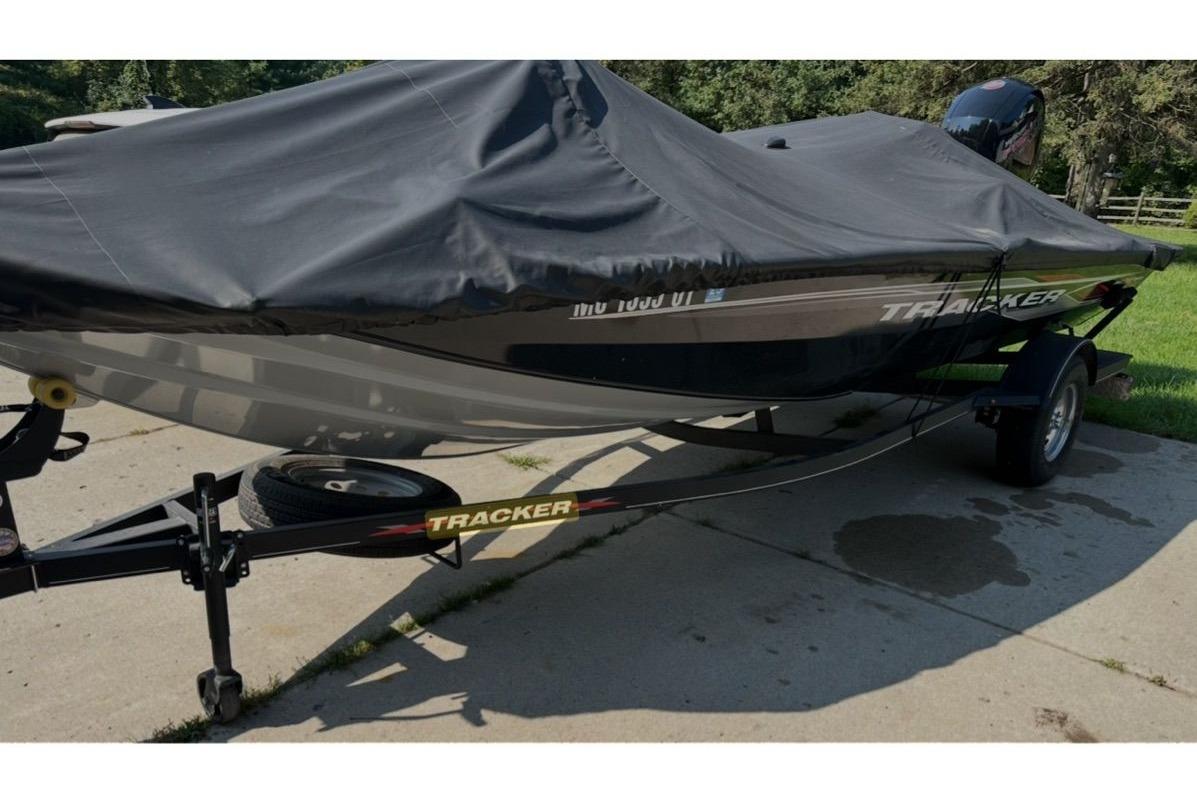 2022 Bass Tracker 195TXW boat covered on trailer, parked on driveway.