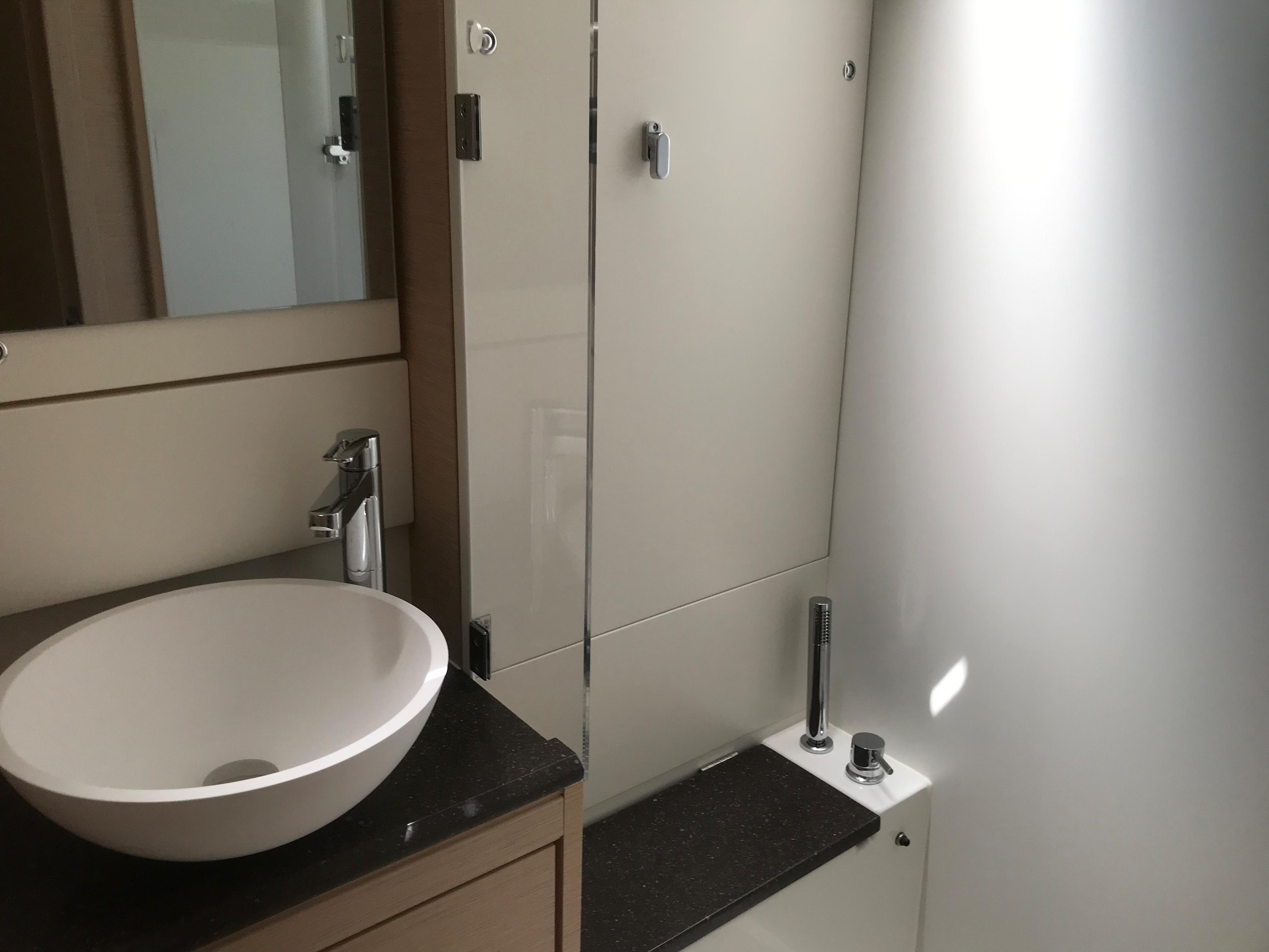 Modern bathroom interior on 2020 Jeanneau 54 yacht with sleek sink and shower.
