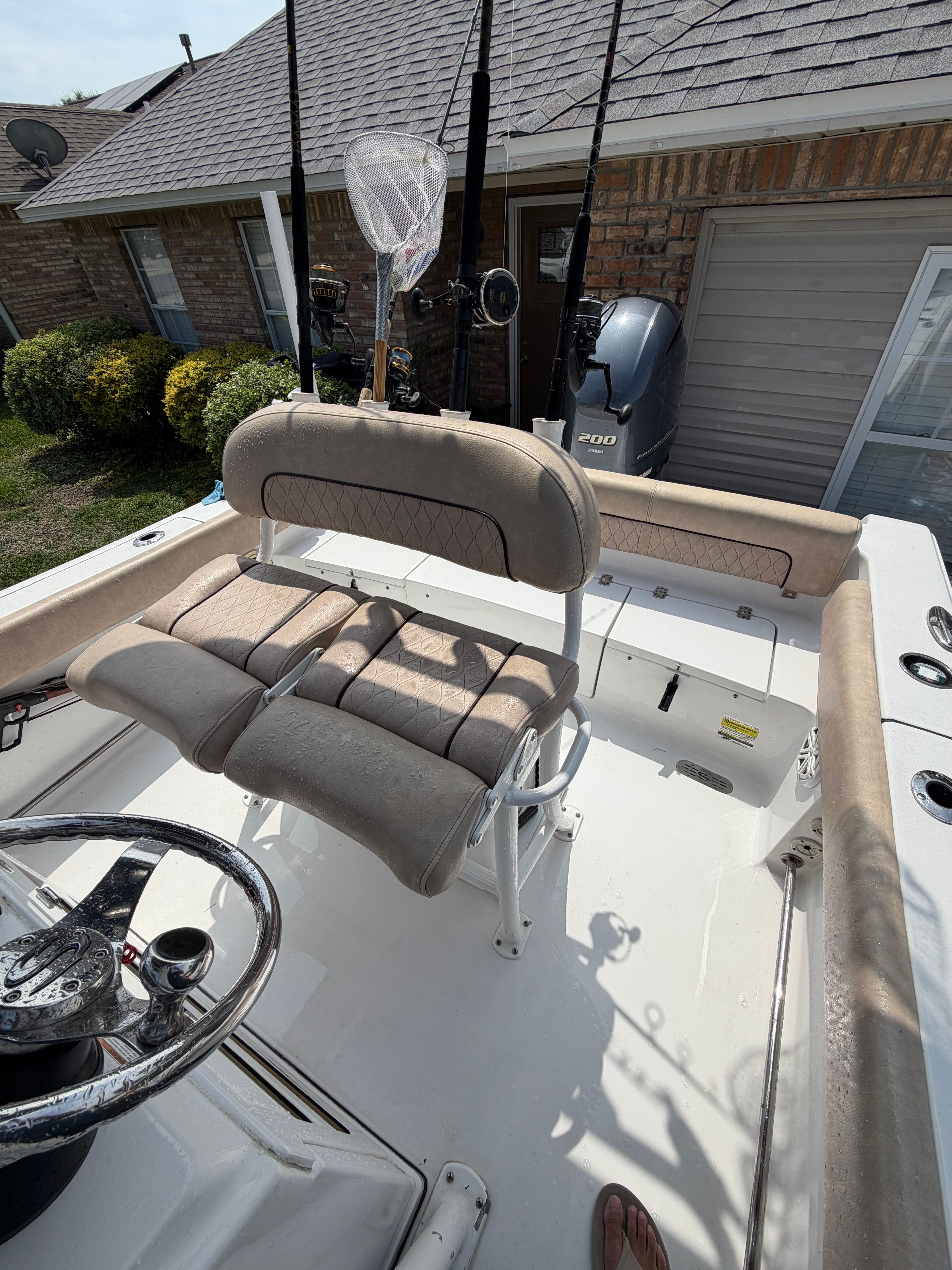 The image shows the cockpit of a 2020 Sportsman Heritage 211 Center Console boat. It features cushioned seats and fishing rod holders.
