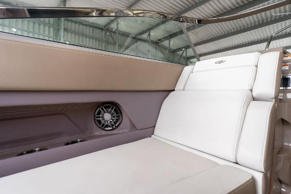 Interior seating of 2016 Regal 28 Express boat, featuring white upholstery and speaker.