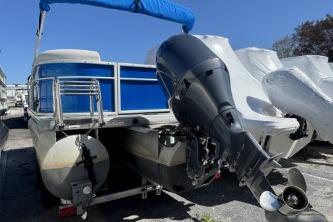 2021 Godfrey Sweetwater 2286 C pontoon boat with outboard motor, blue canopy, docked outdoors.