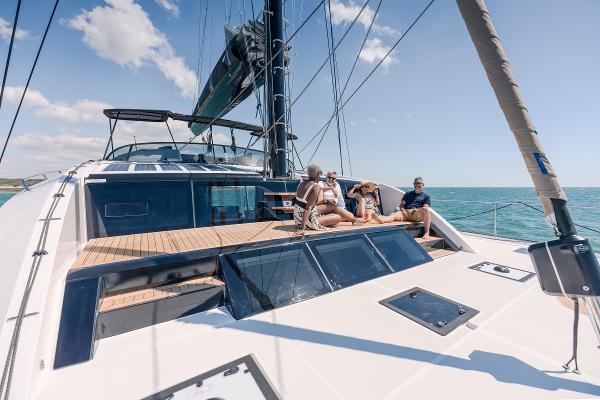 Luxury sailing on Privilege Signature 650 yacht, 2025 model, with people relaxing on deck.