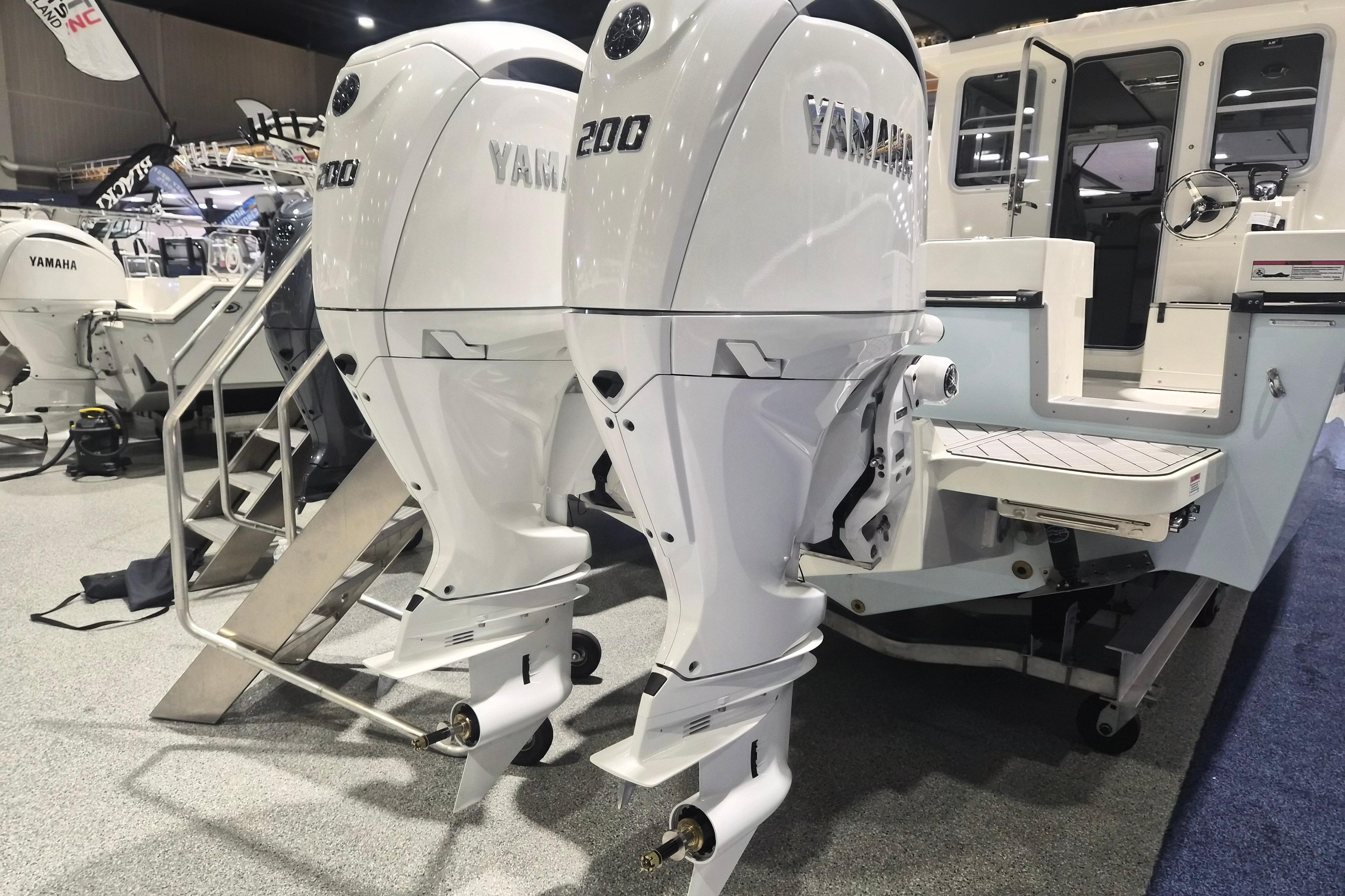 Twin Yamaha outboard engines on a 2026 Defiance Admiral 260 EX boat at a showroom.