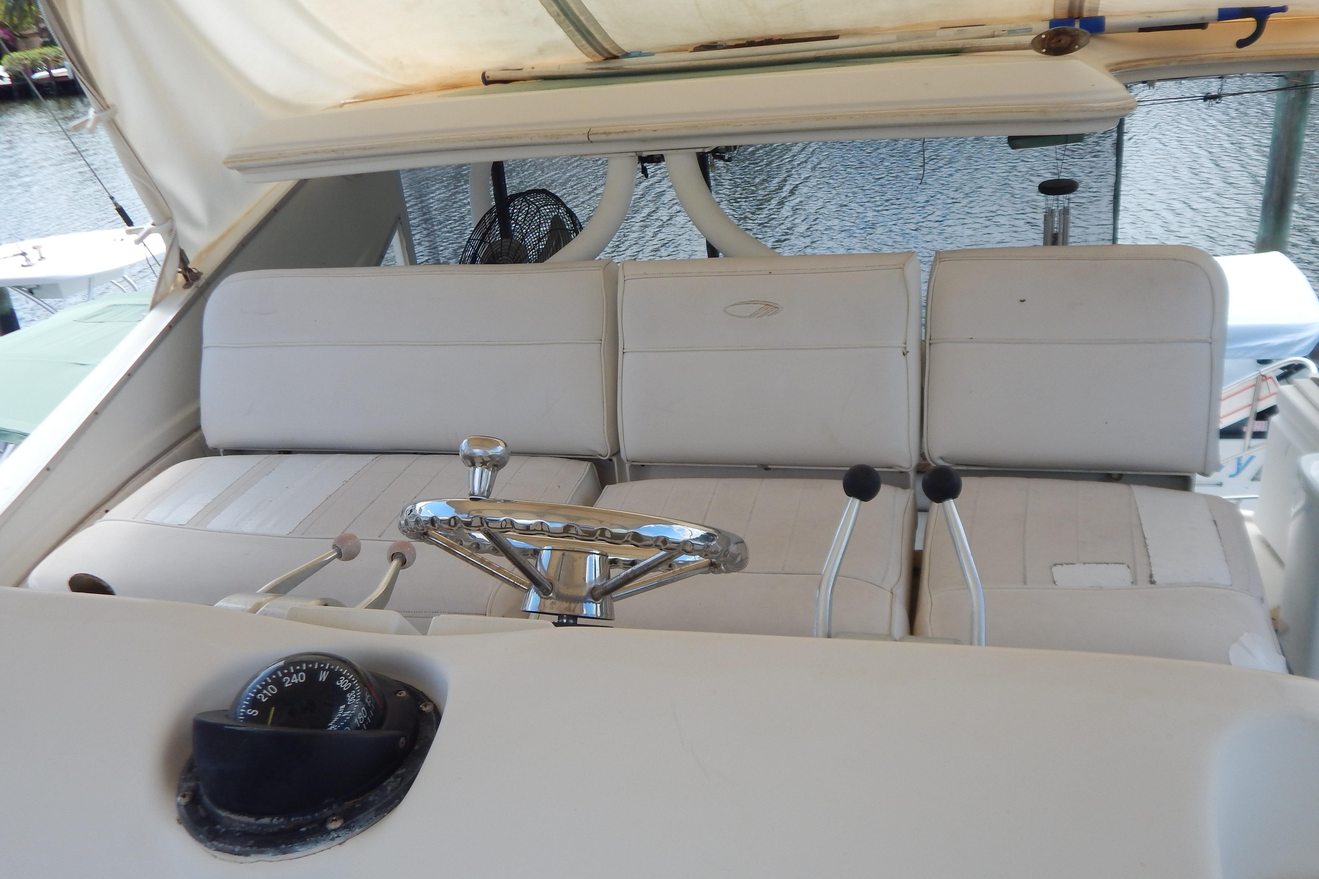 1998 Magnum 4100 SCR boat helm with white seating and steering wheel.