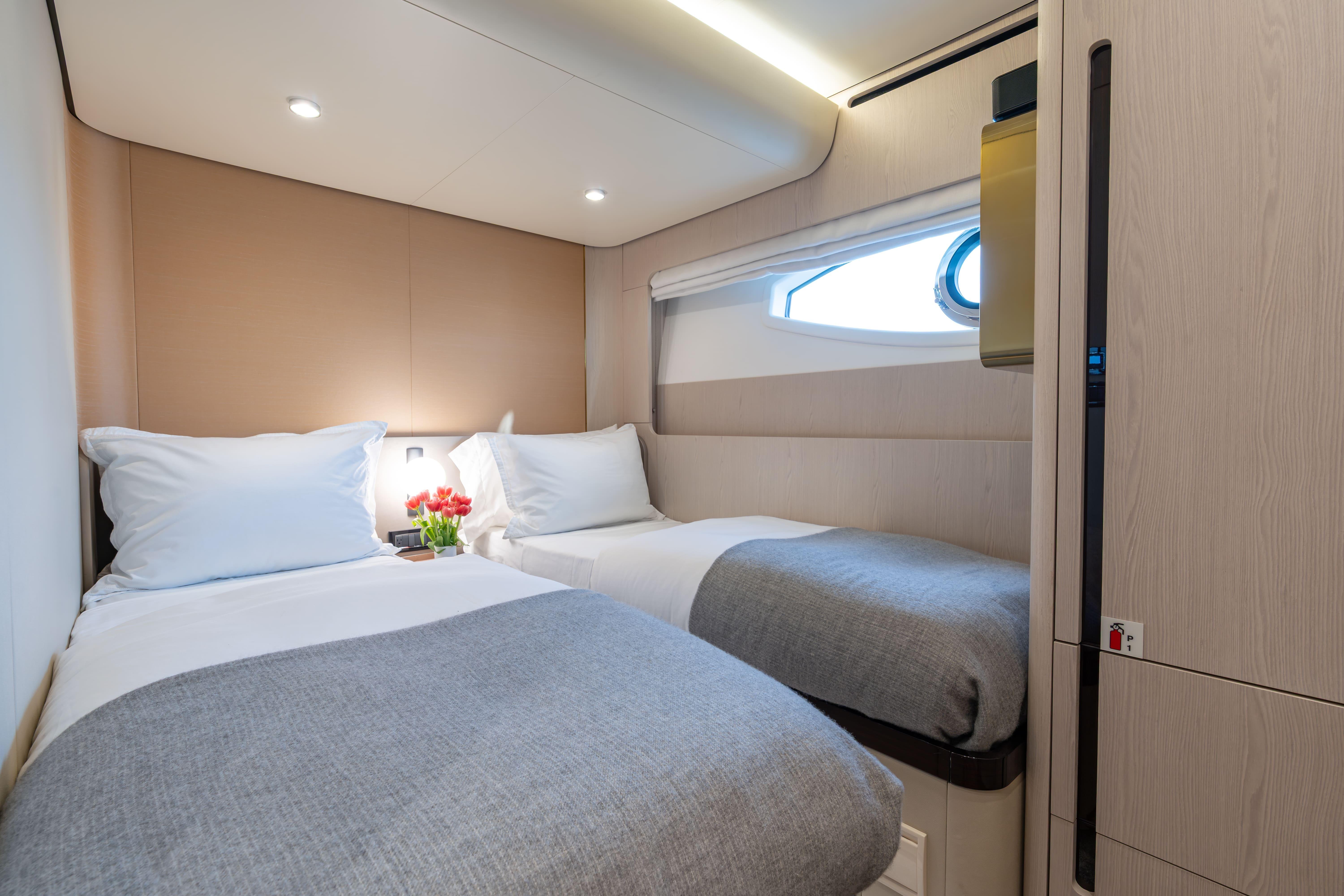 Luxurious twin cabin interior on 2022 Azimut 78 yacht, featuring modern design and cozy bedding.