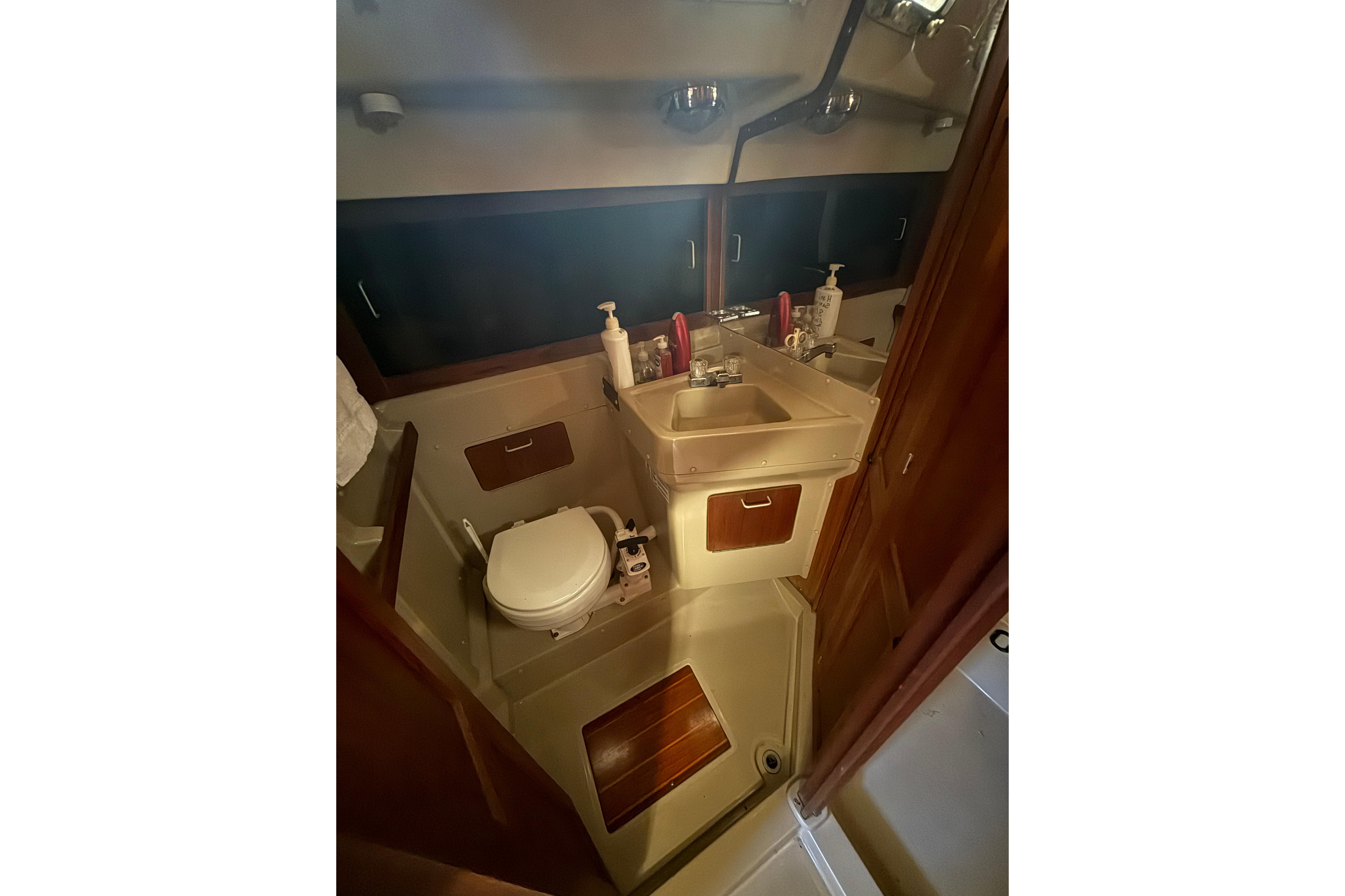 1983 O'Day 34 sailboat bathroom with sink, toilet, and storage cabinets.