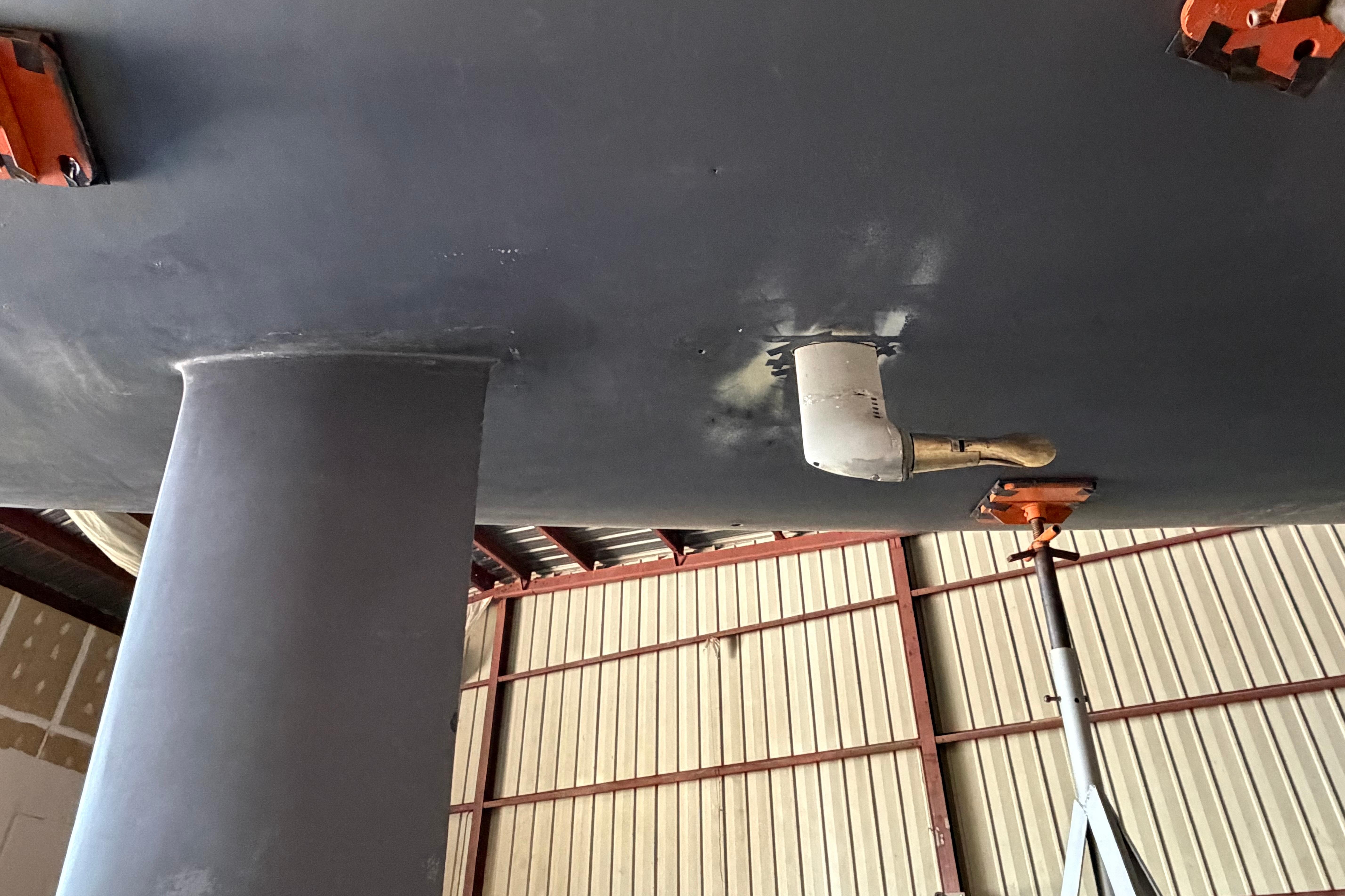 Bottom view of Andrews 63 boat hull in a workshop setting.