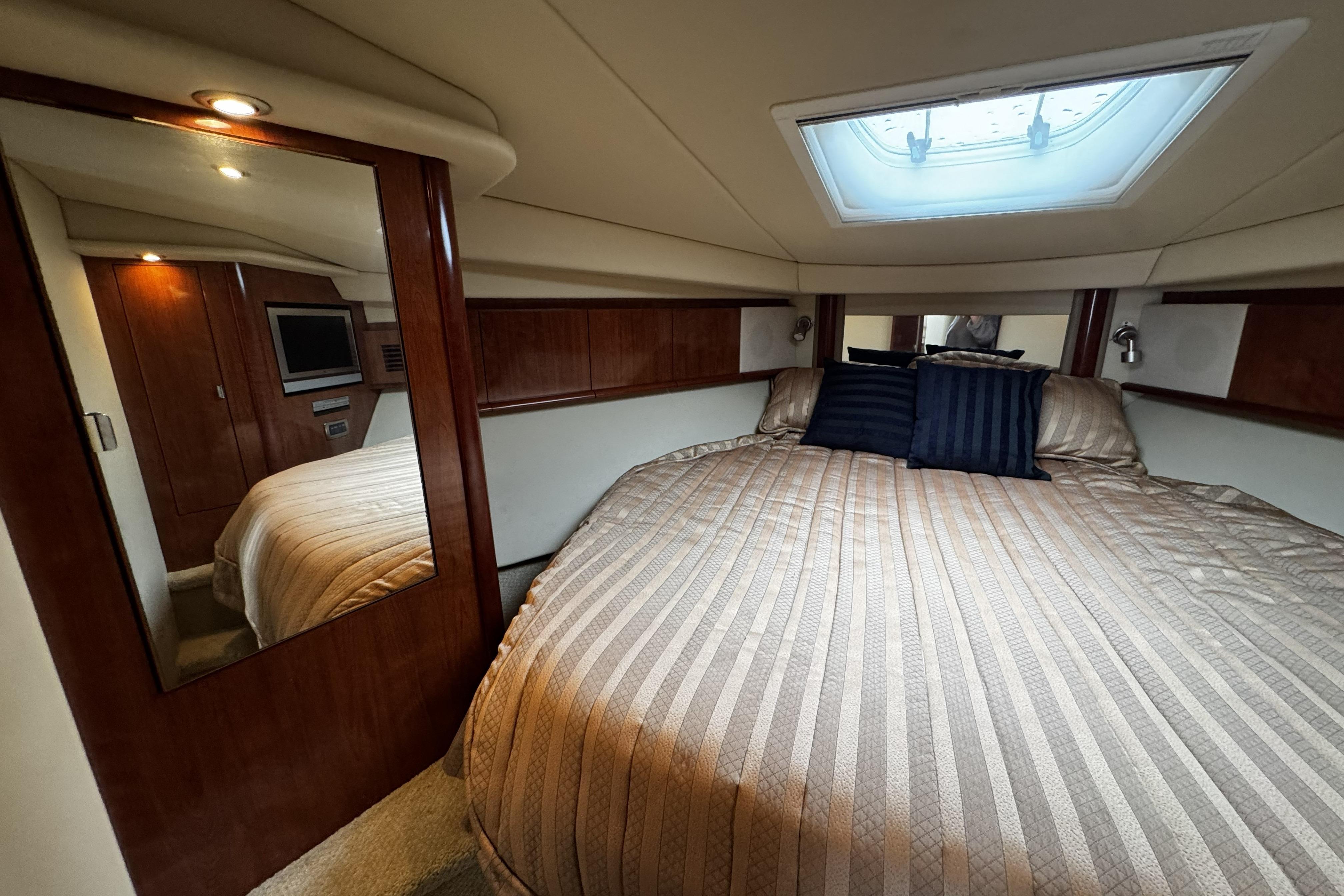 Luxurious cabin interior of 2006 Sea Ray 40 Sundancer yacht with cozy bedding.