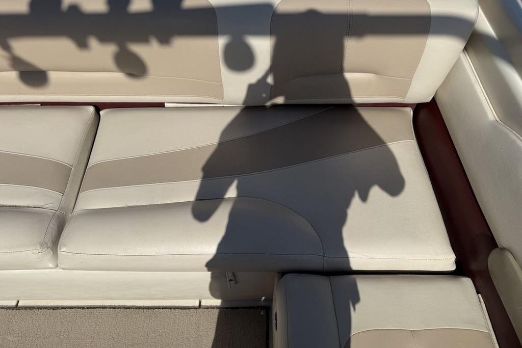 Shadow on beige leather seats of a 1999 Glastron GT 225 boat interior.