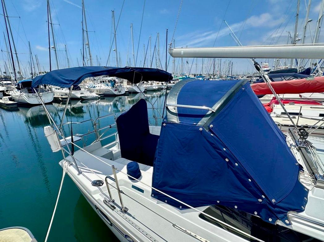 2007 Catalina 36 MkII sailboat with blue canopy docked in marina.