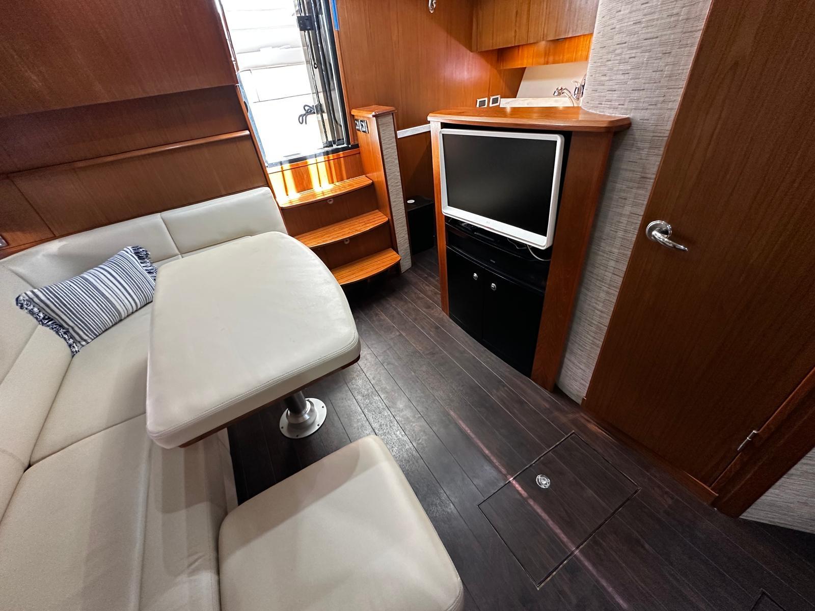Luxurious interior of 2014 Tiara Yachts 39 Coronet with seating, TV, and wooden finishes.