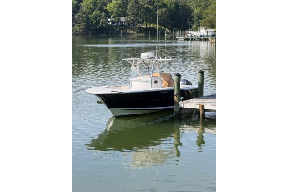 2014 Southport 29 FE boat docked on calm water with lush greenery.