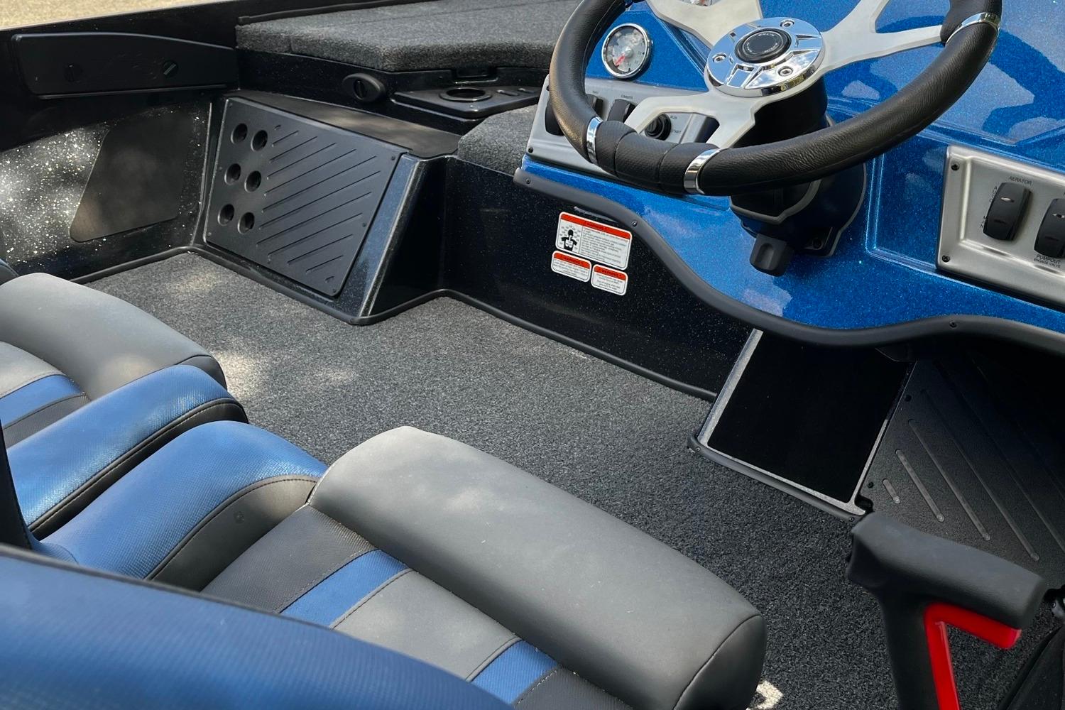 Interior of a 2025 Nitro Z18 boat featuring blue and black seating and steering console.